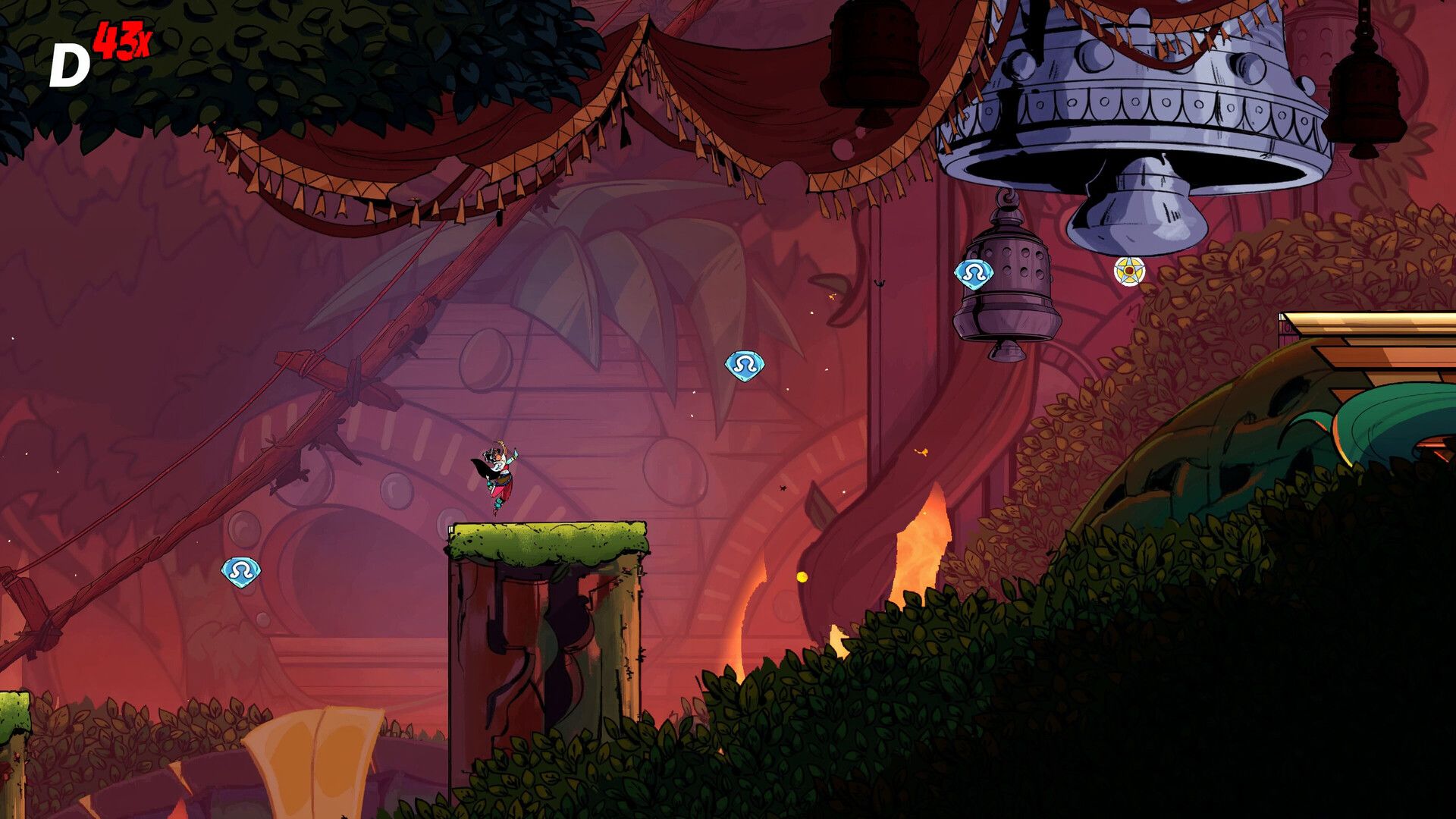 Ajira jumps below hanging bells in a red-lit area.