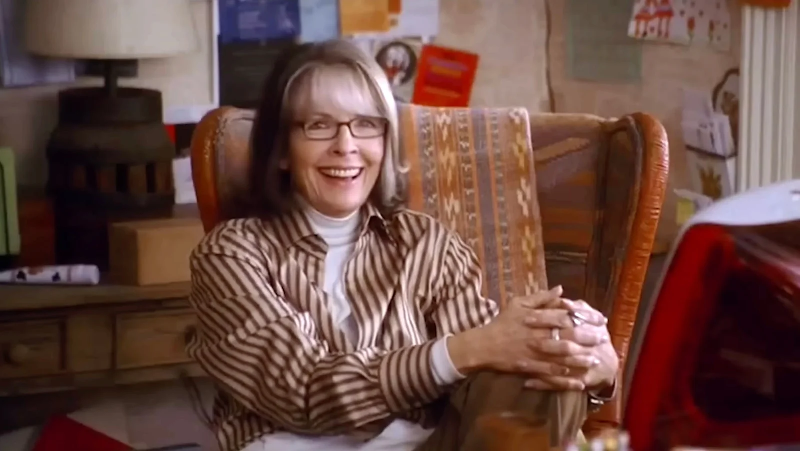 Diane Keaton sits smiling in a chair as Sybil Stone in The Family Stone.