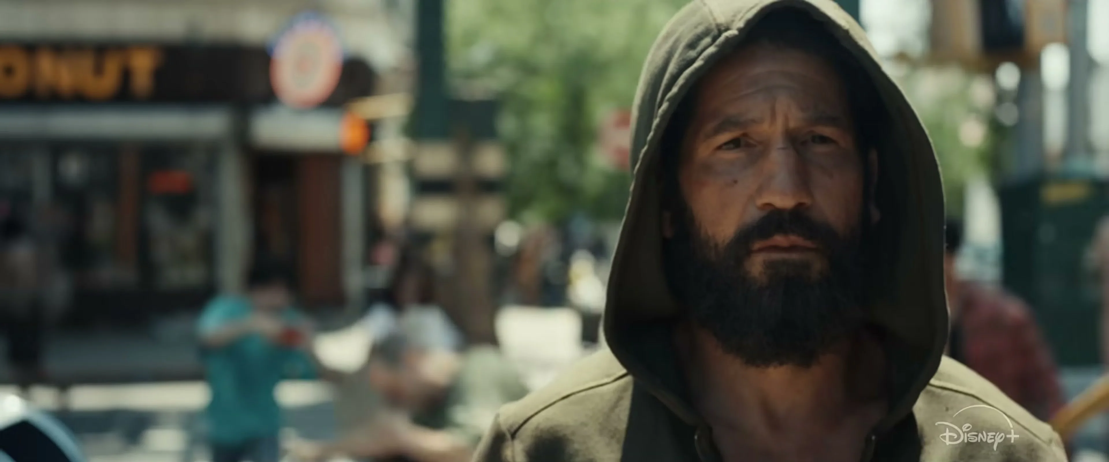 Jon Bernthal wears a dark hood on a city street in The Punisher: One Last Kill.