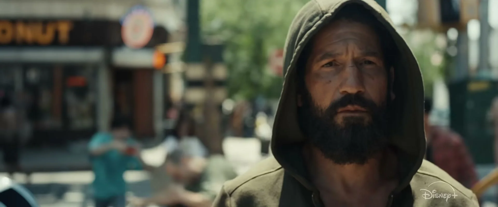 Jon Bernthal wears a dark hood on a city street in The Punisher: One Last Kill.