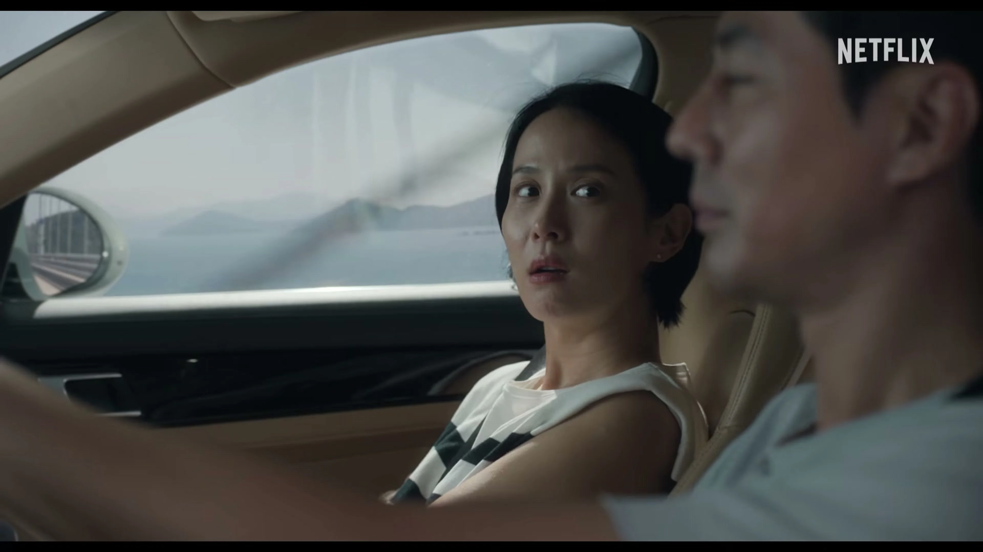 Ye-ji sits beside Sang-woo in a car and looks toward him.