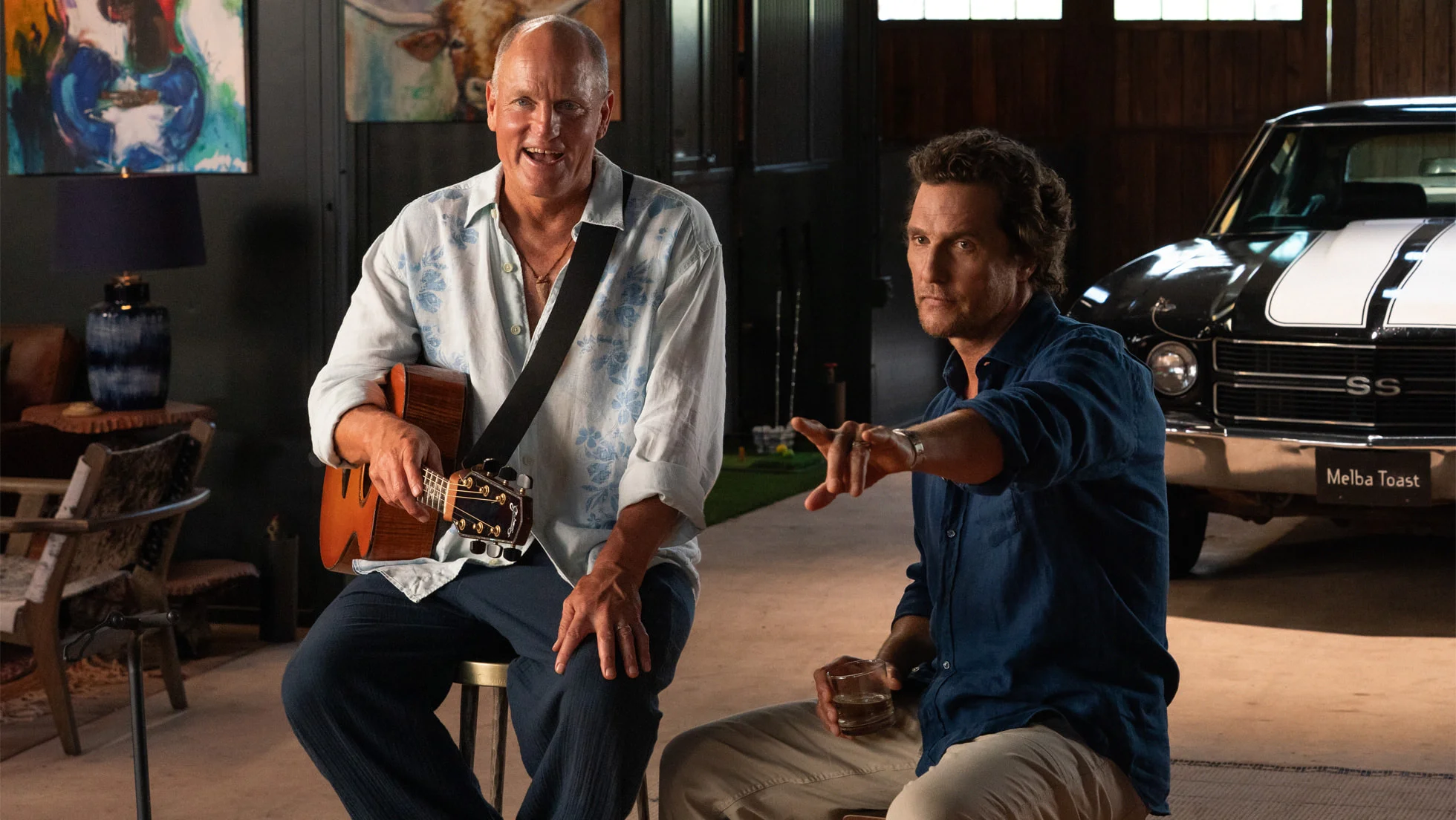 Woody Harrelson holds a guitar beside Matthew McConaughey in a scene from Brothers.