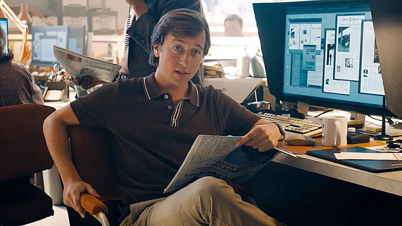 Skyler Gisondo as Jimmy Olsen sits at his Daily Planet desk in Superman.