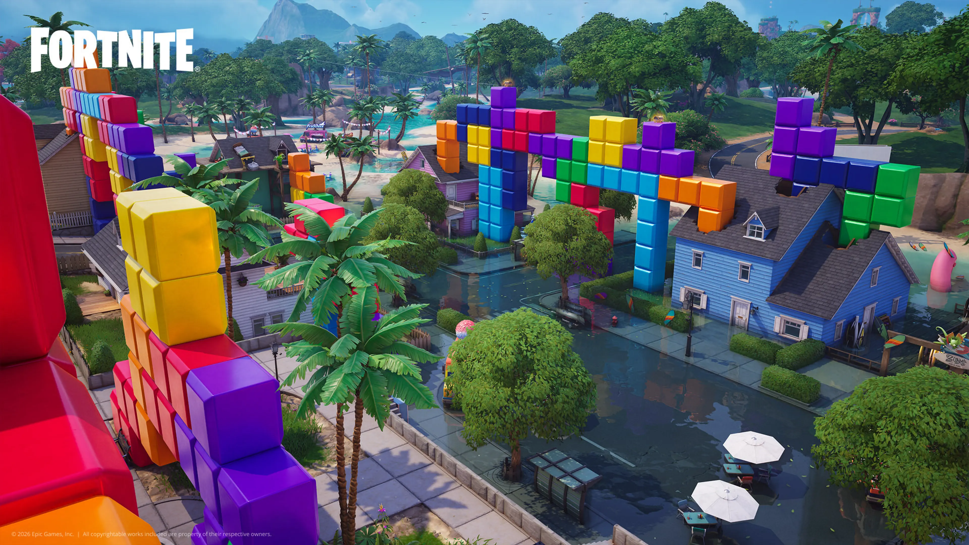 Colorful blocks rise above houses and trees in a Fortnite island location.