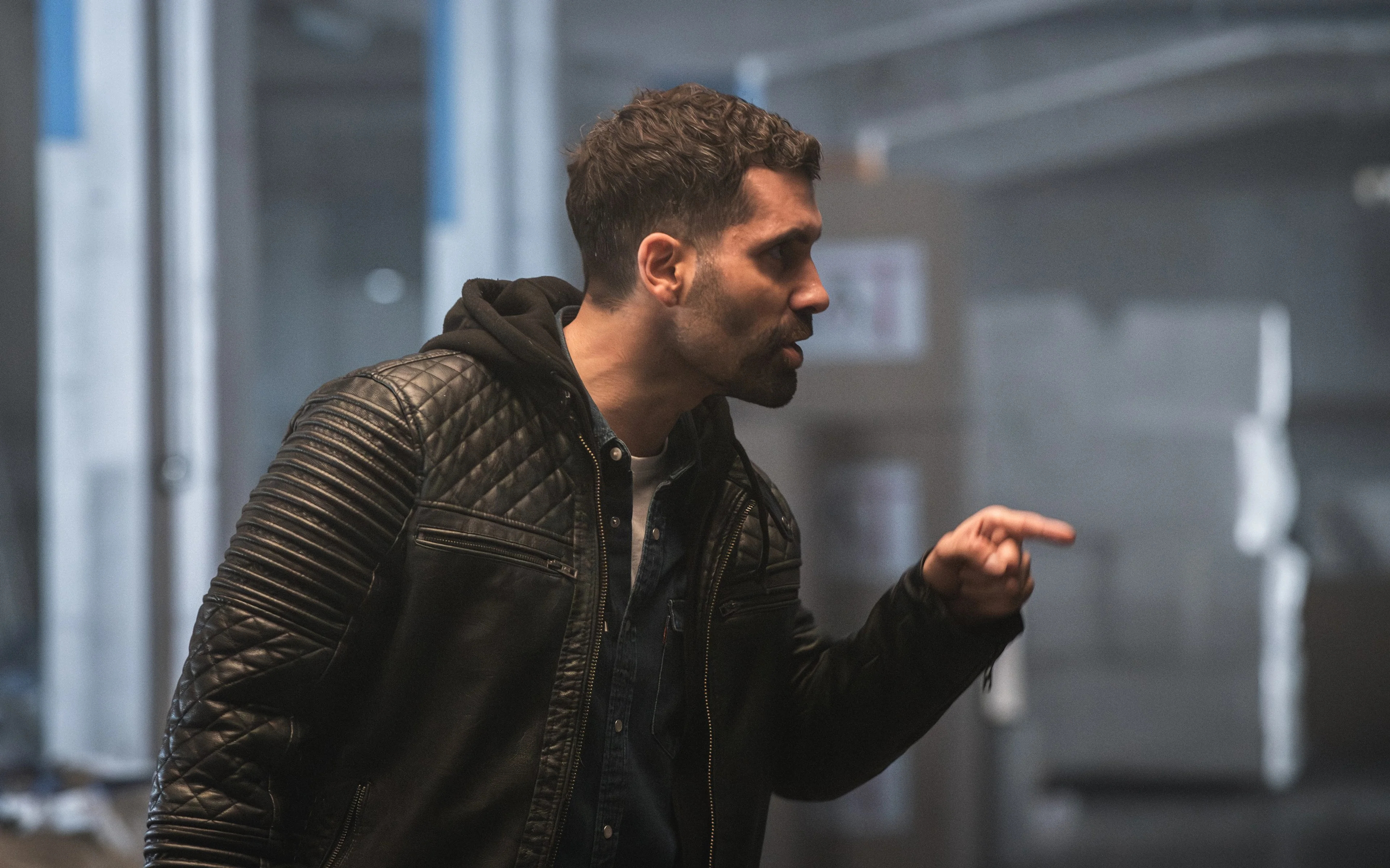 A man gestures across an office.