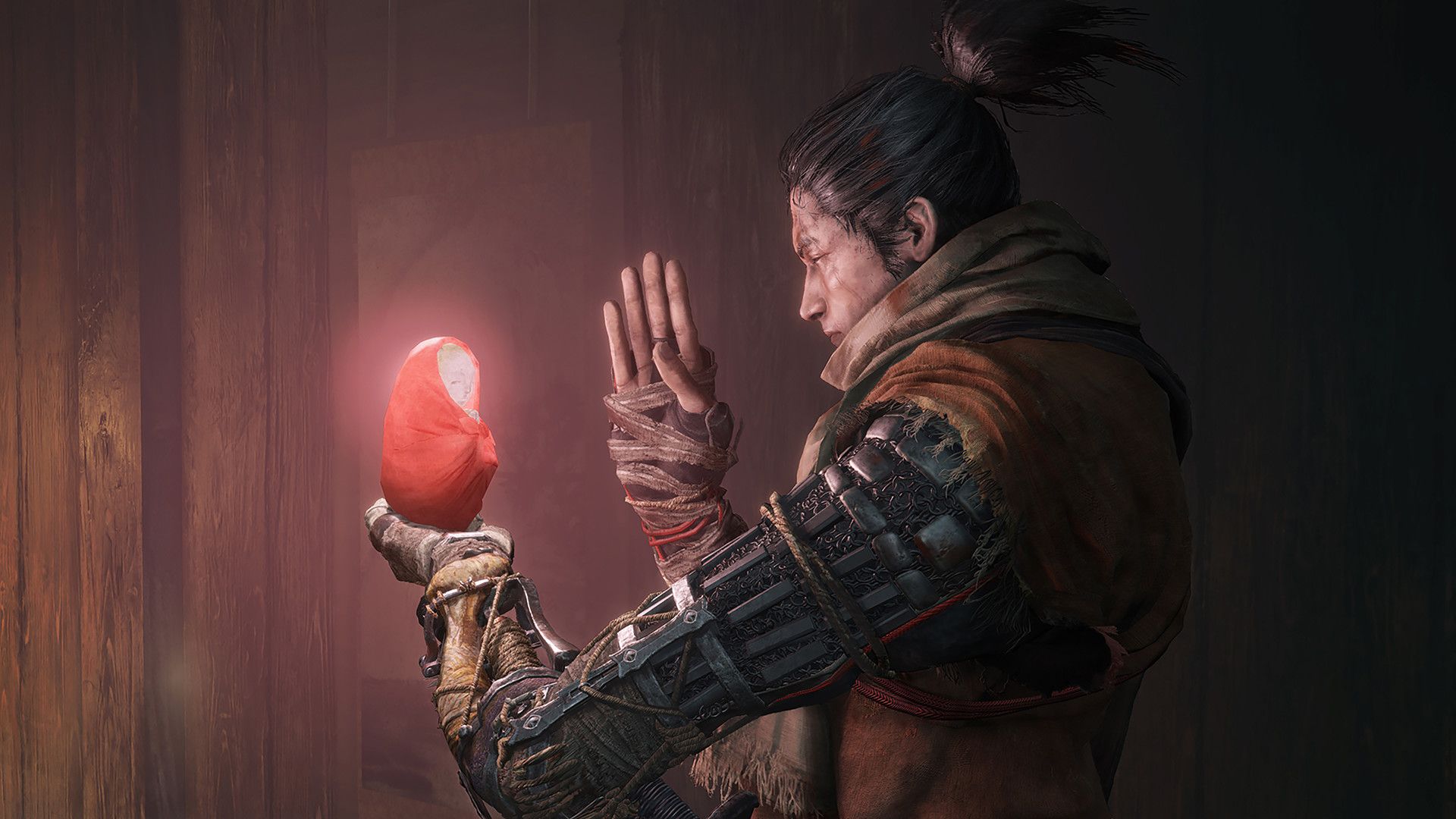 Wolf holds a glowing red object beside his shinobi prosthetic arm.
