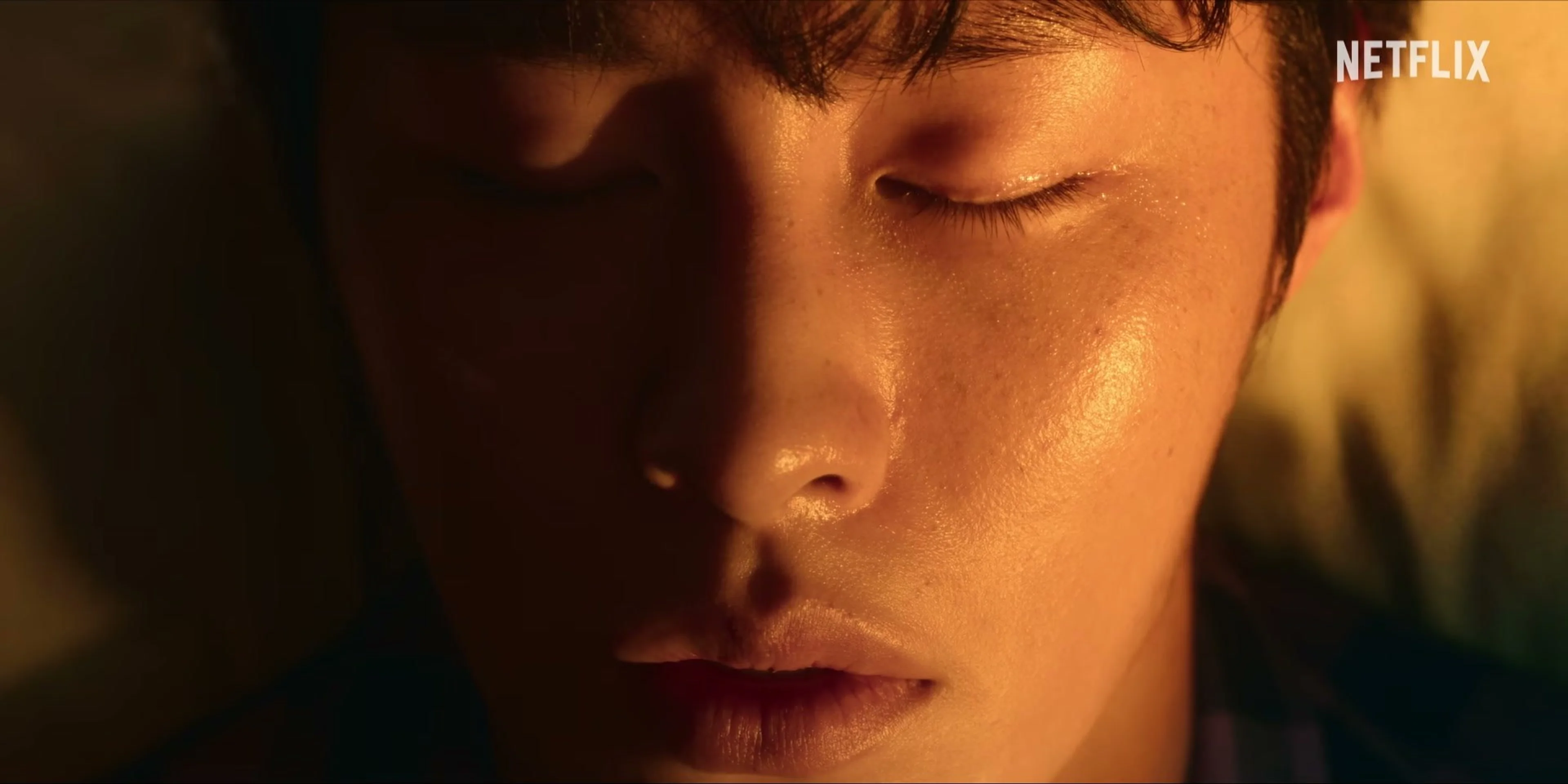 A close-up of a young man with his eyes closed.