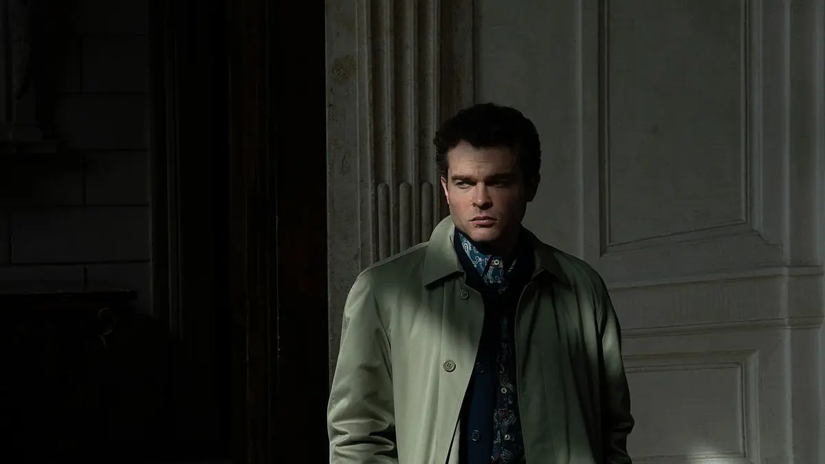 Alden Ehrenreich as Edward stands in a doorway in A Talent for Murder.