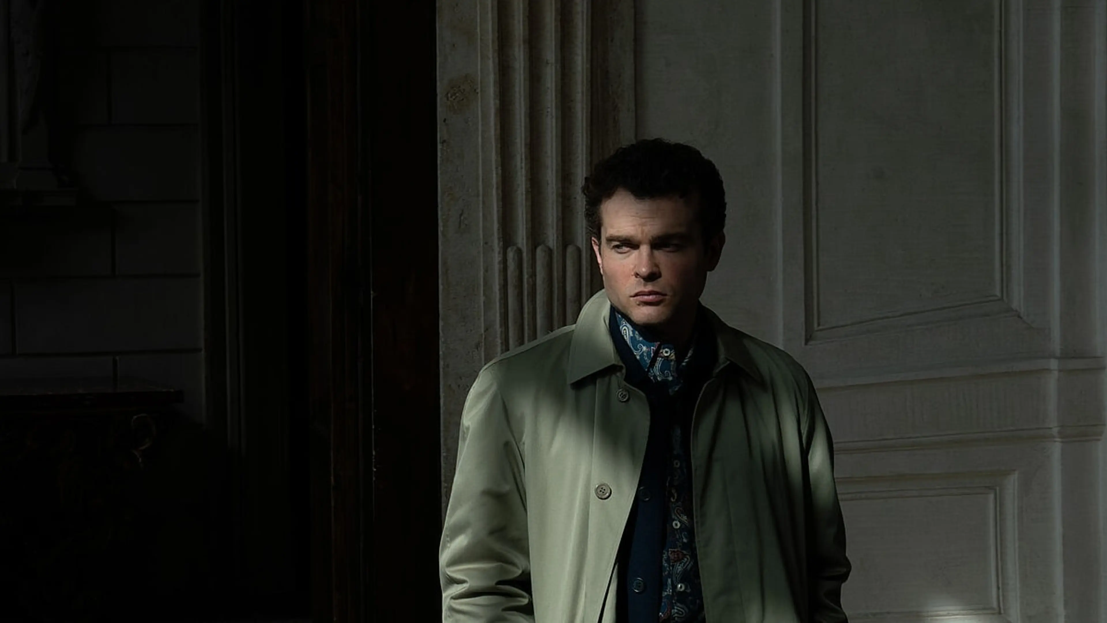 Alden Ehrenreich as Edward stands in a doorway in A Talent for Murder.