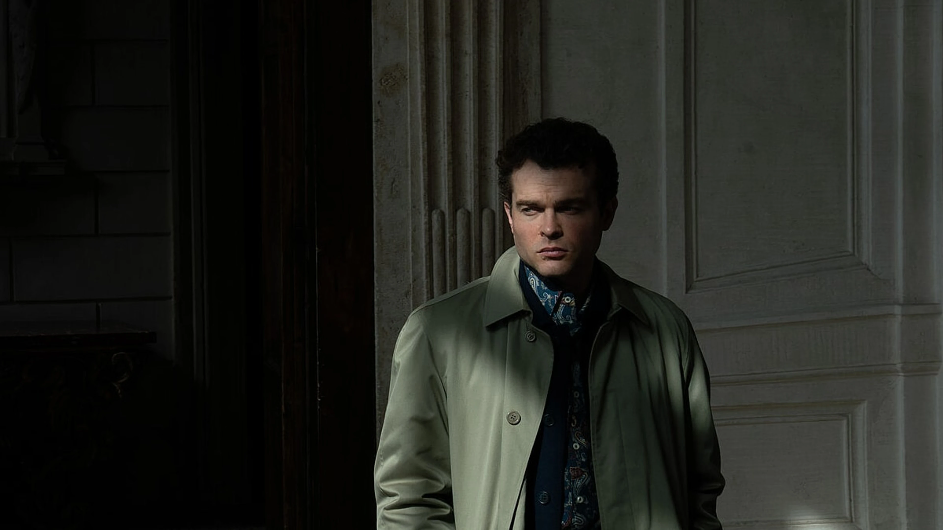 Alden Ehrenreich as Edward stands in a doorway in A Talent for Murder.