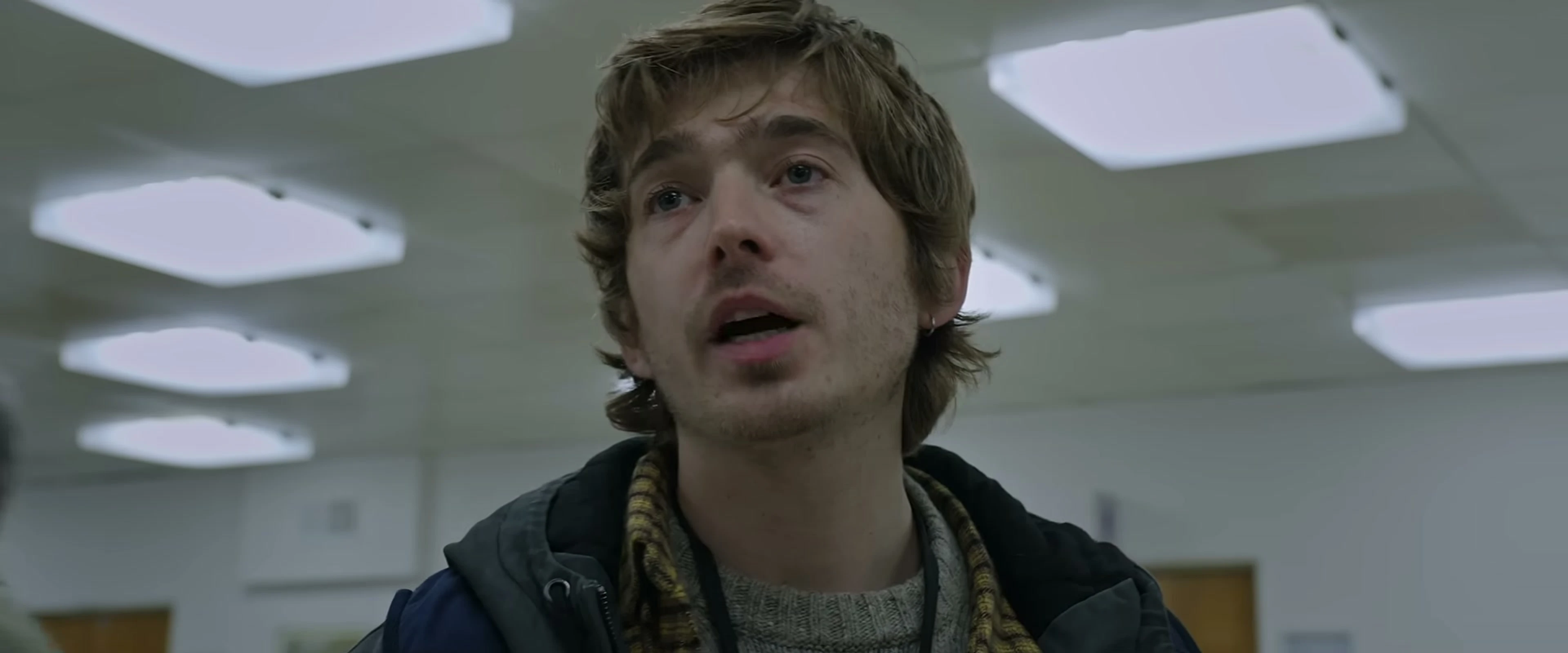 Austin Abrams looks up inside Raccoon City General Hospital in Resident Evil.