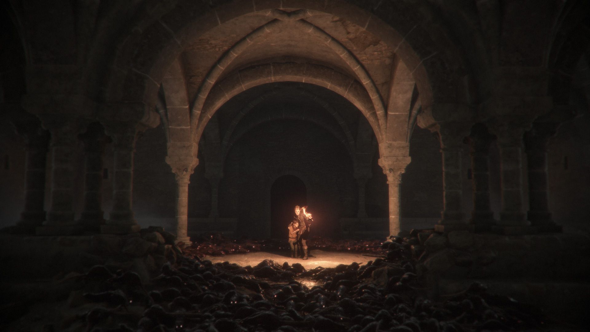 A small light glows in a dark stone hall with rats along the floor.