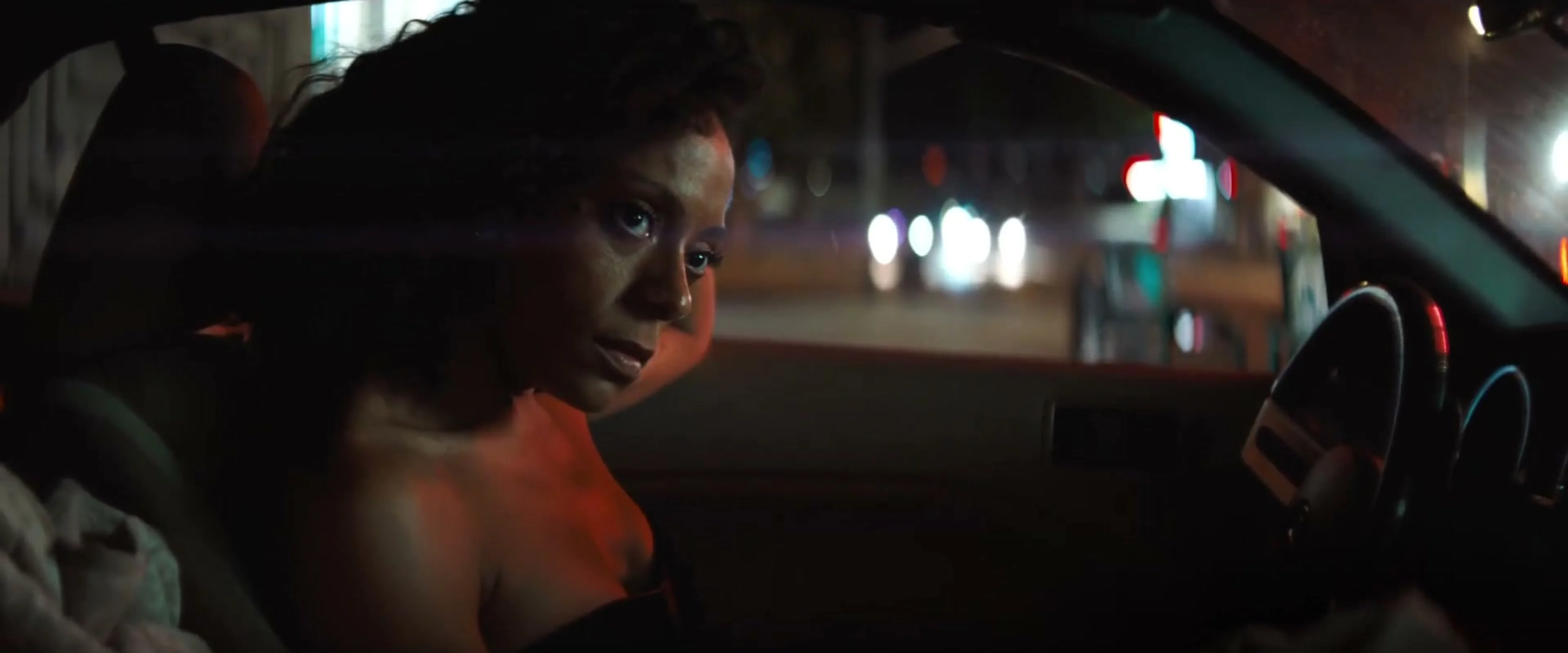 Rosalind Eleazar as Misty Green seated in a car in an official film scene.