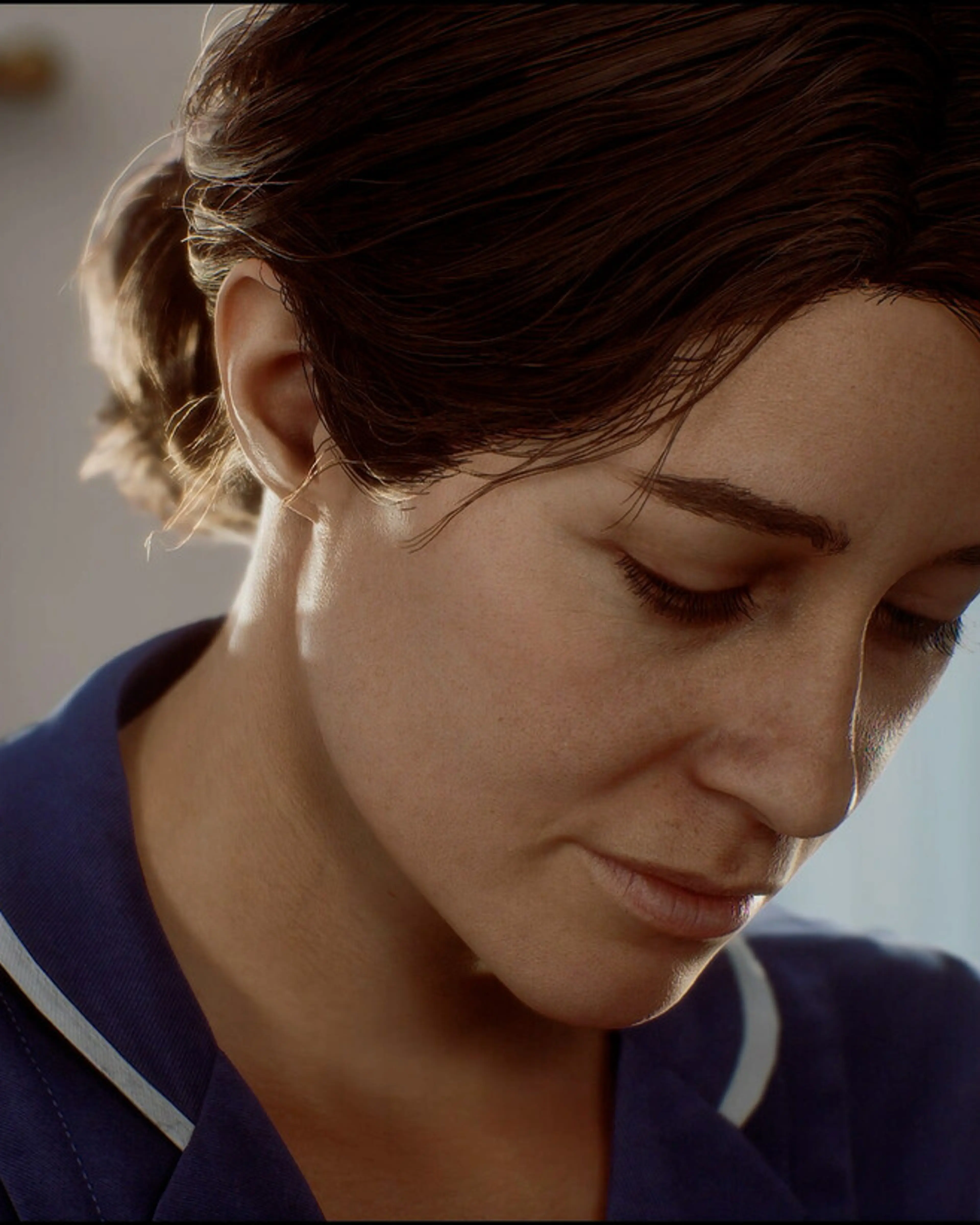 Zoe wears a dark medical uniform and looks downwards.