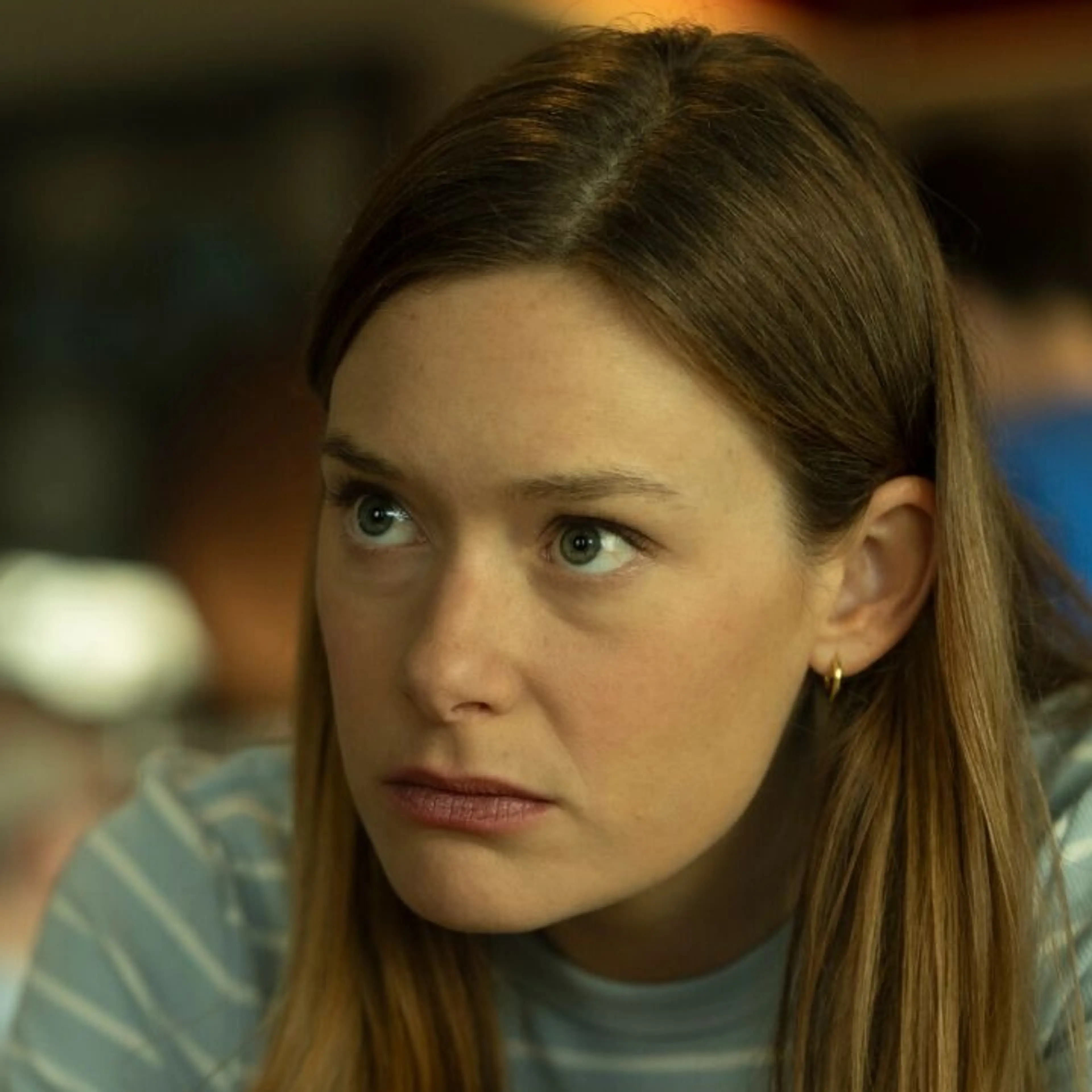 Rachel Keller as Olivia Siffre, leaning across a table in an official Cupertino production photograph.