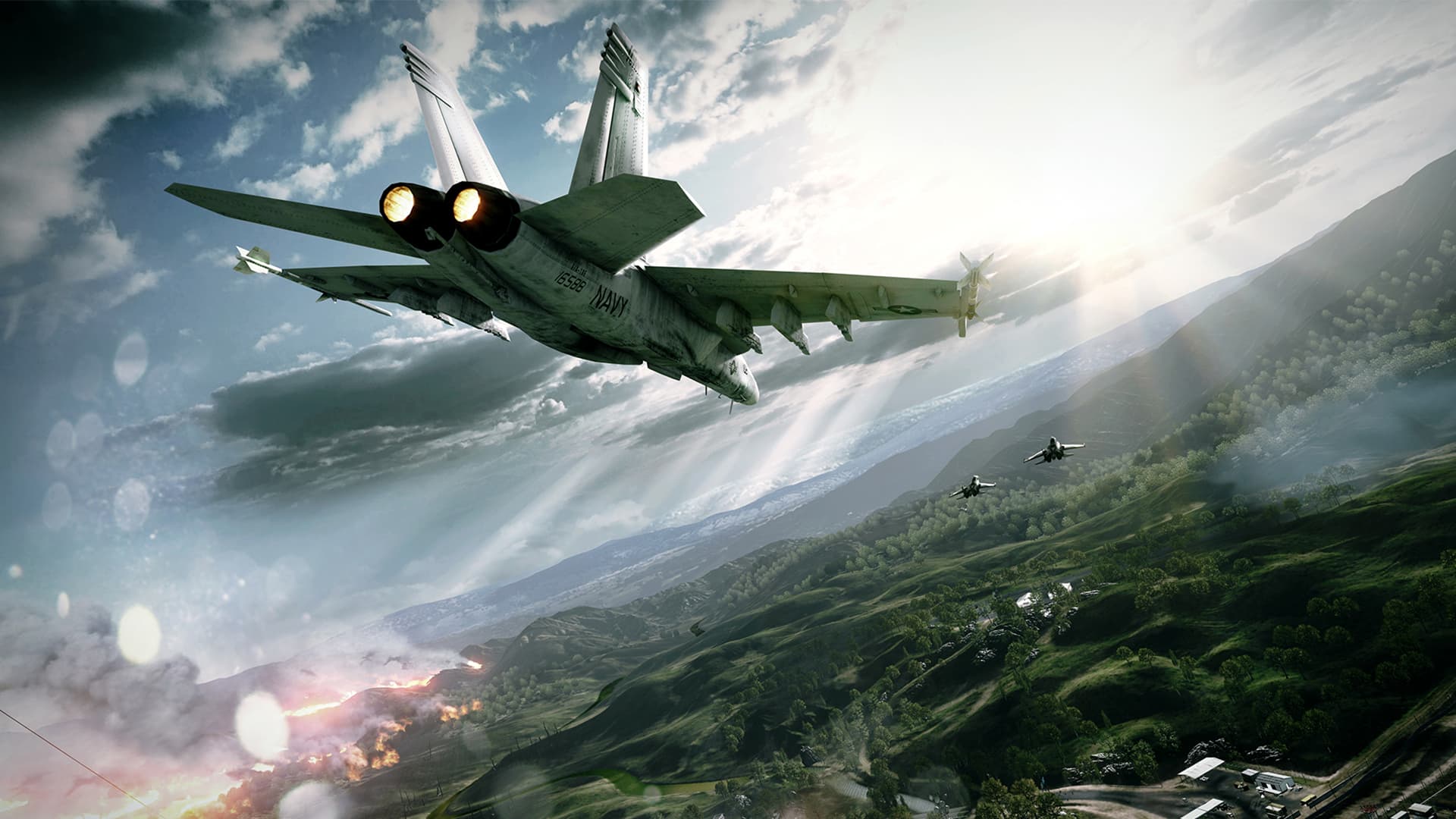 A fighter jet flies above a green landscape with another jet farther away.