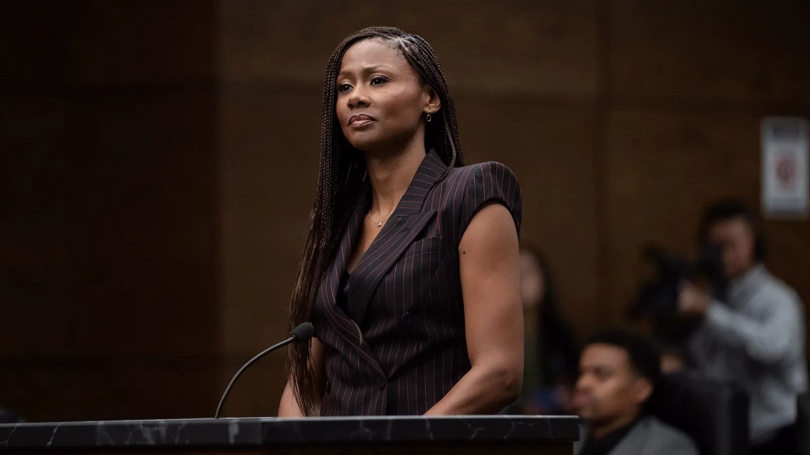 Emayatzy Corinealdi as Jax Stewart stands at a courtroom lectern.