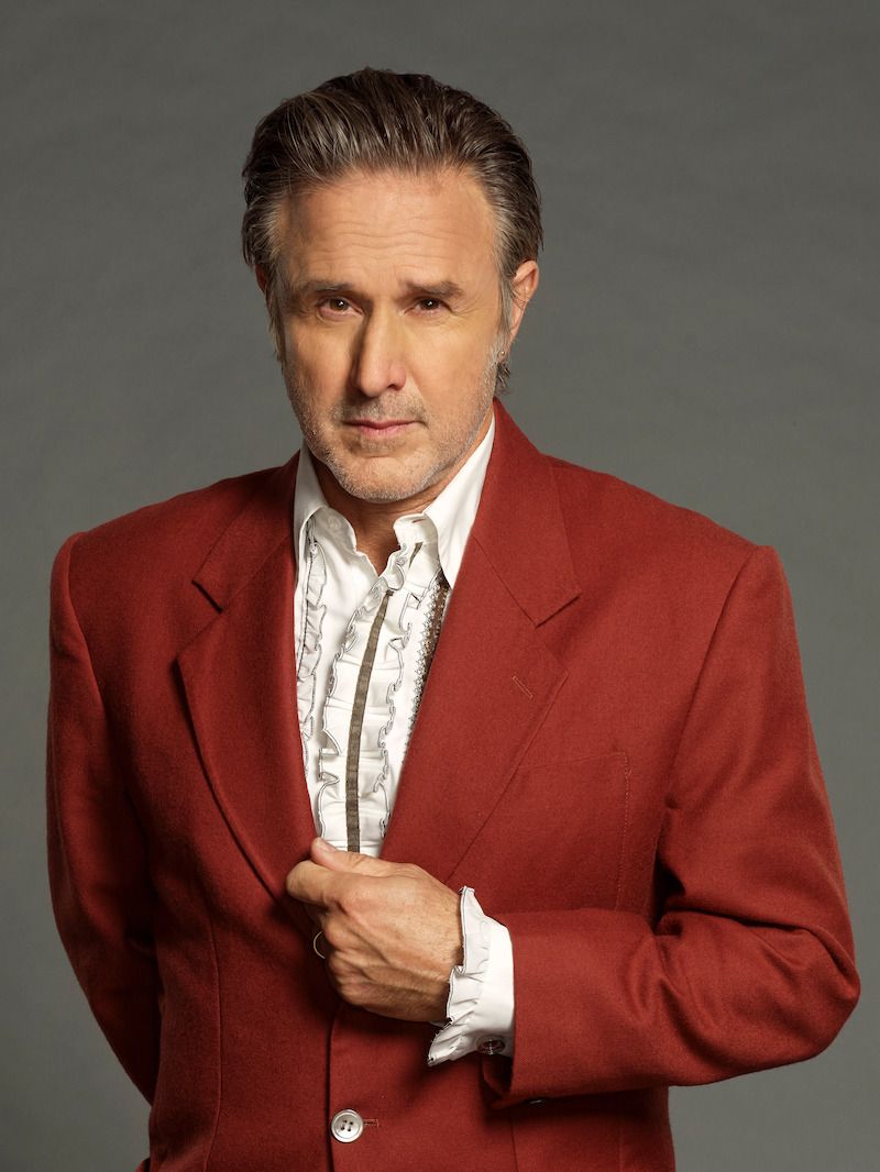 David Arquette poses in a red jacket for Celebrity Million Dollar Secret.