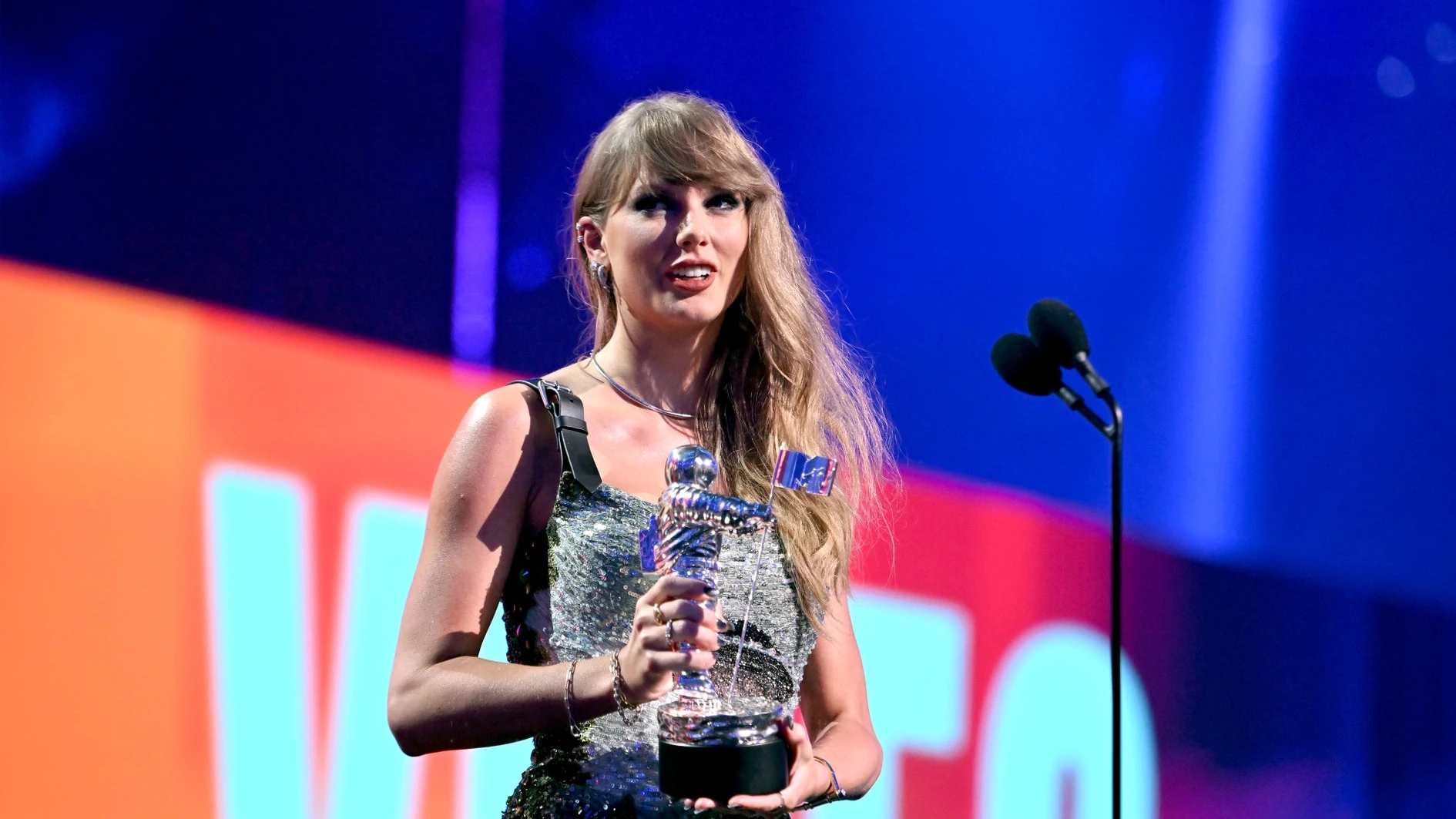 Taylor Swift holding a Moon Person trophy onstage at the 2024 MTV Video Music Awards.