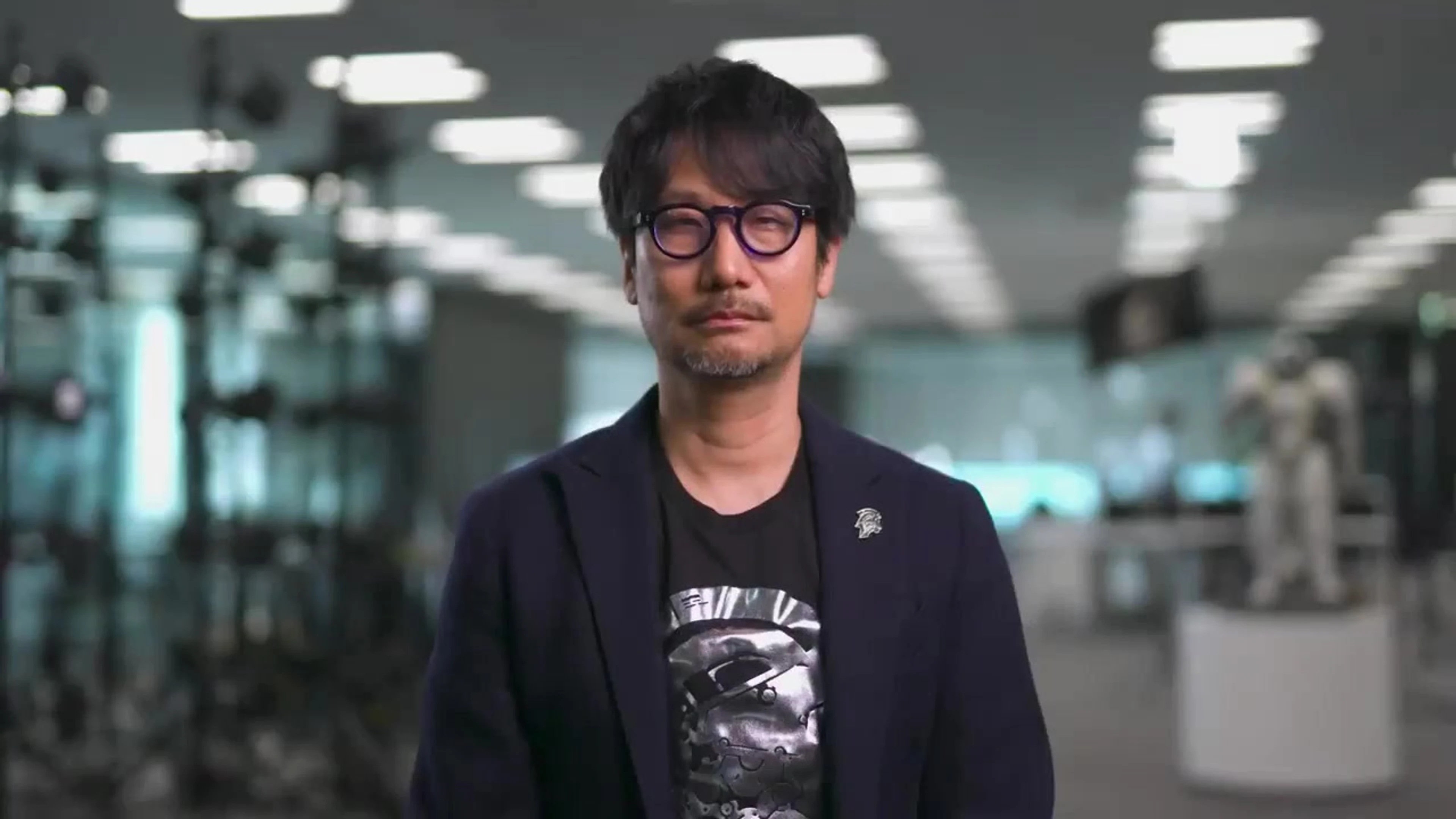 Hideo Kojima stands centered inside Kojima Productions during an official Xbox presentation.