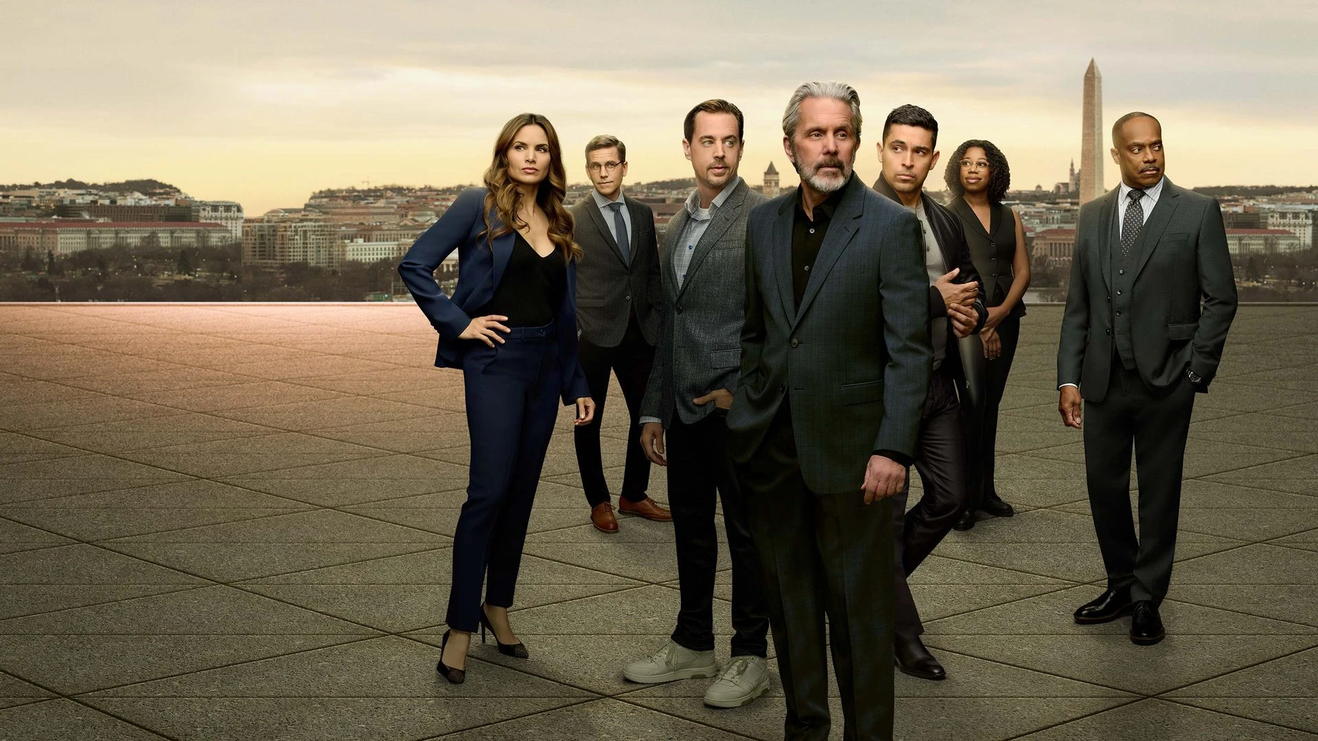 The NCIS ensemble stands against the Washington, D.C. skyline in official CBS series artwork.
