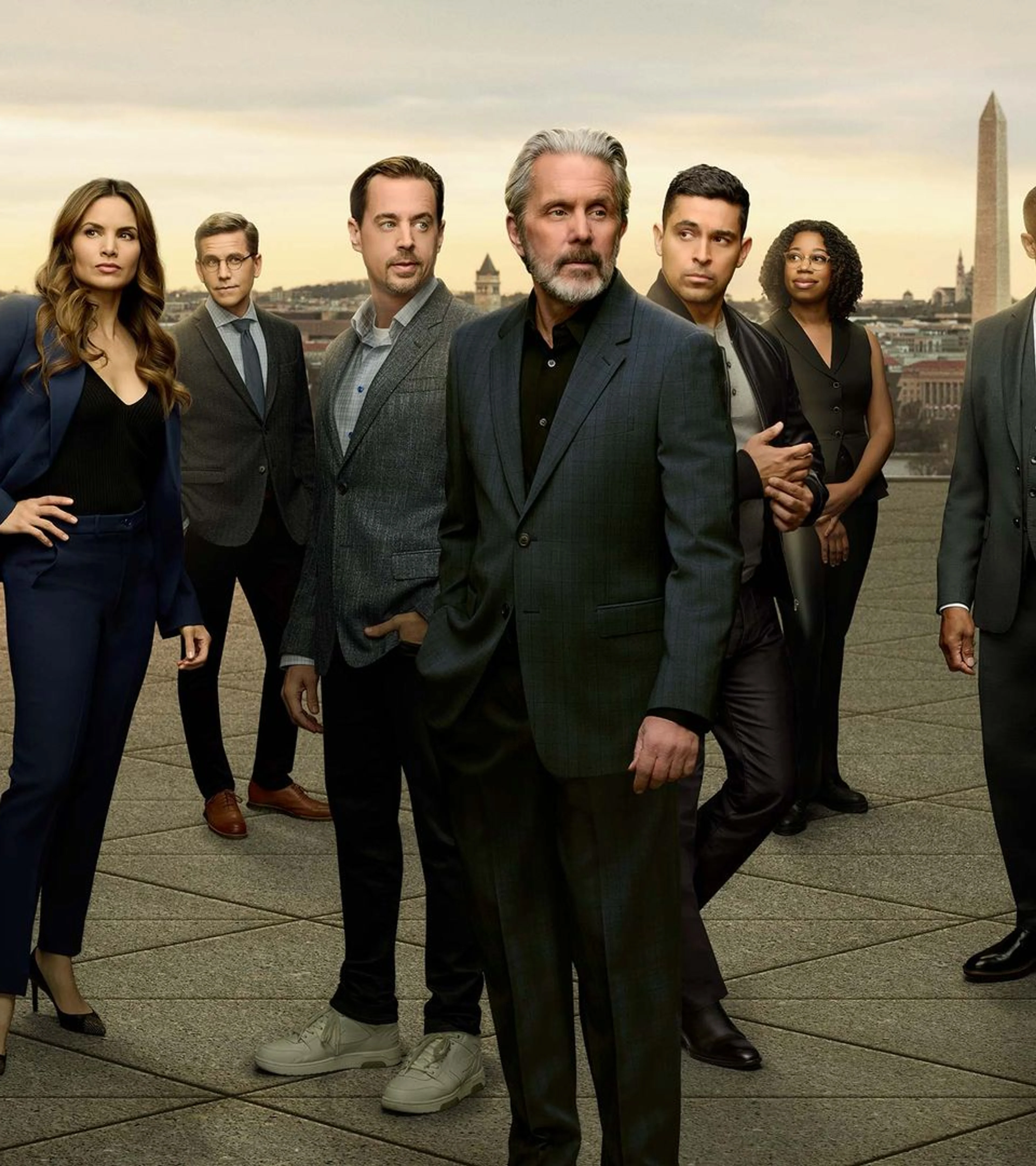 The NCIS ensemble stands against the Washington, D.C. skyline in official CBS series artwork.