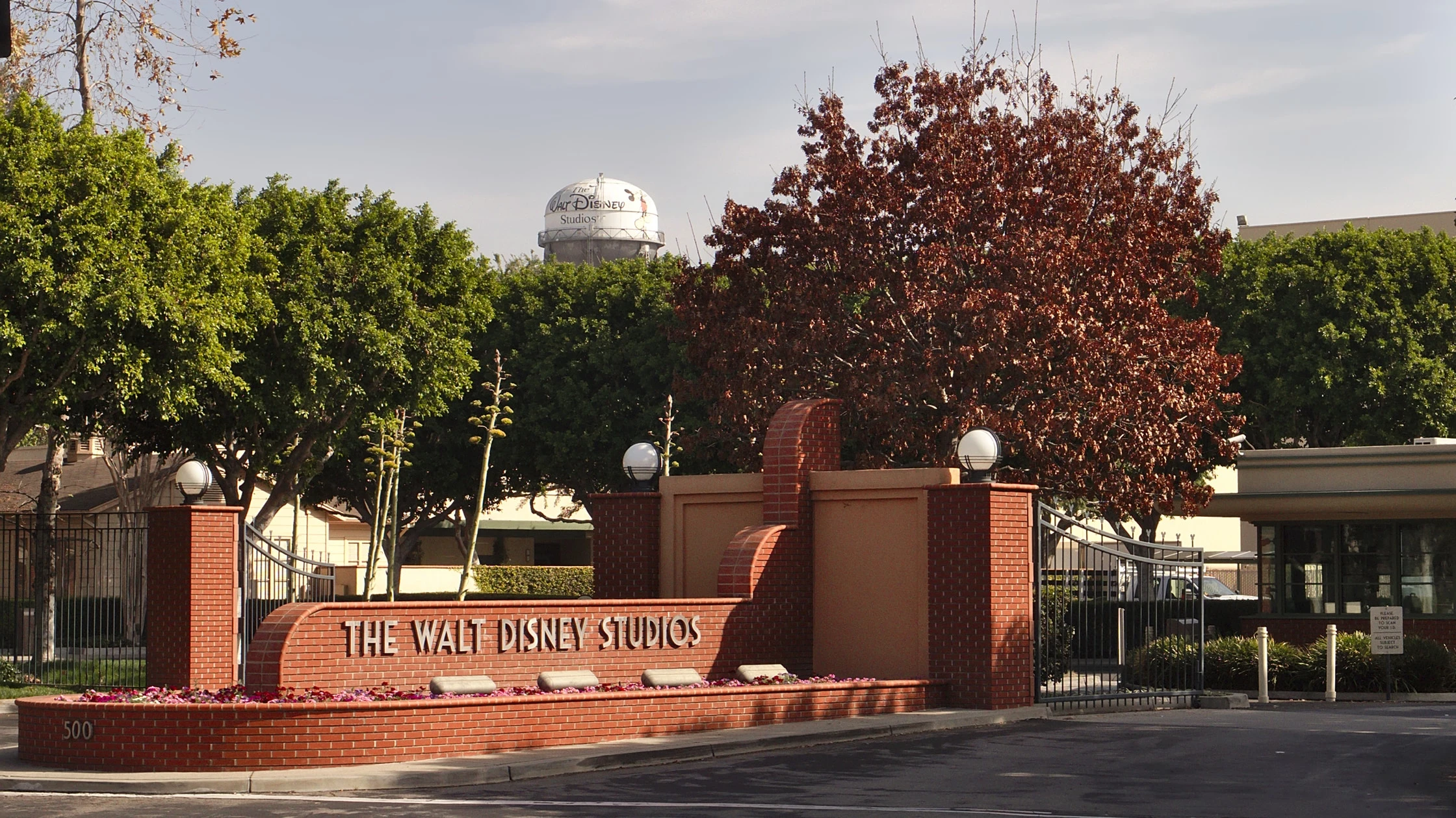 The Walt Disney Studios entrance and water tower stand behind trees in Burbank, California.