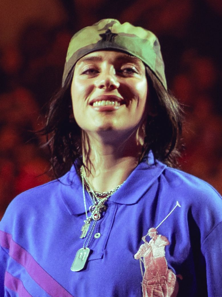 Billie Eilish smiling onstage in London in July 2025.