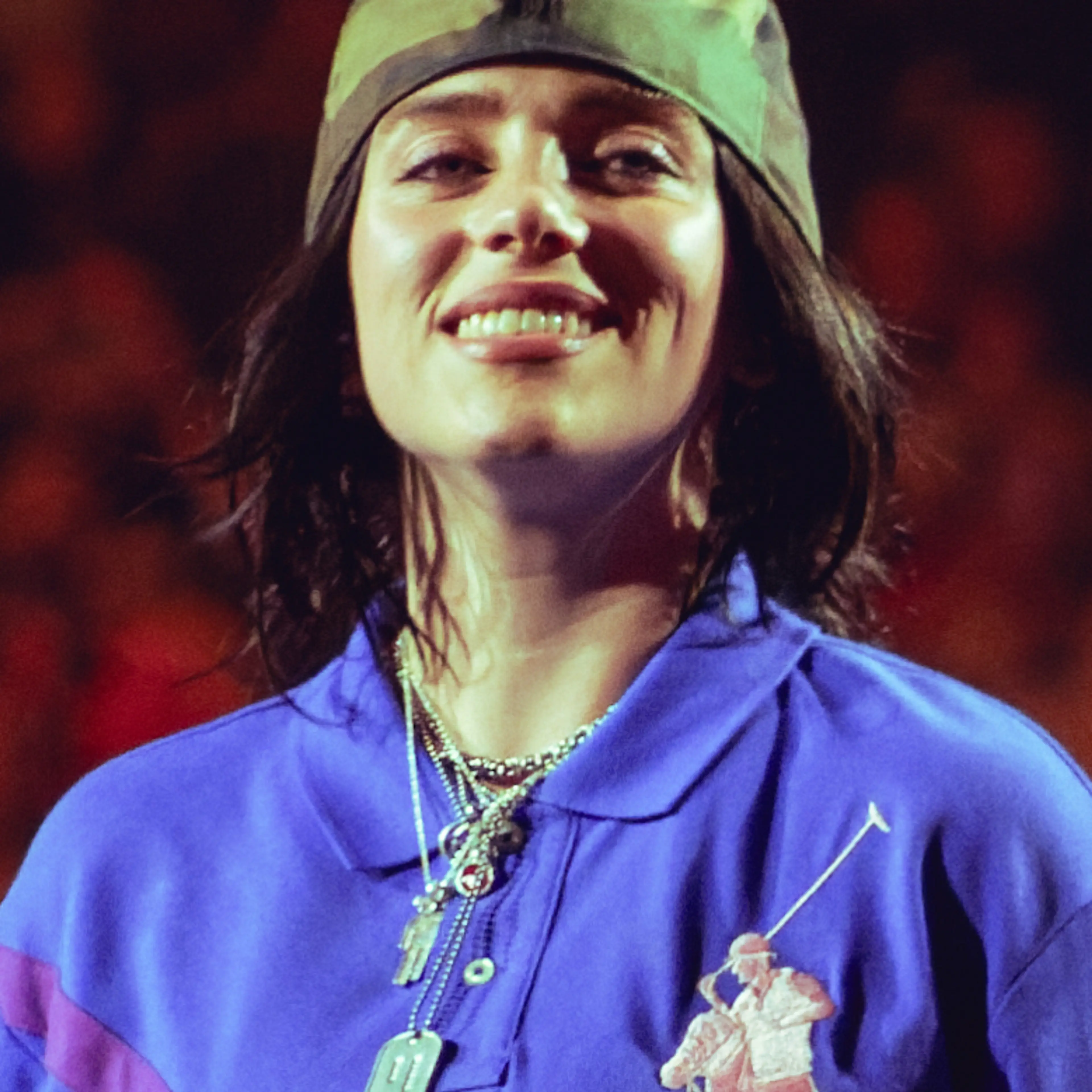 Billie Eilish smiling onstage in London in July 2025.