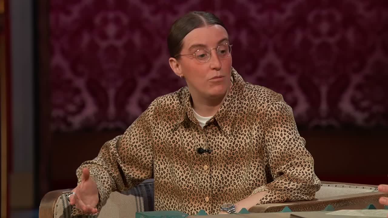 Robby Hoffman talks with Jimmy Kimmel in a patterned shirt and round glasses.