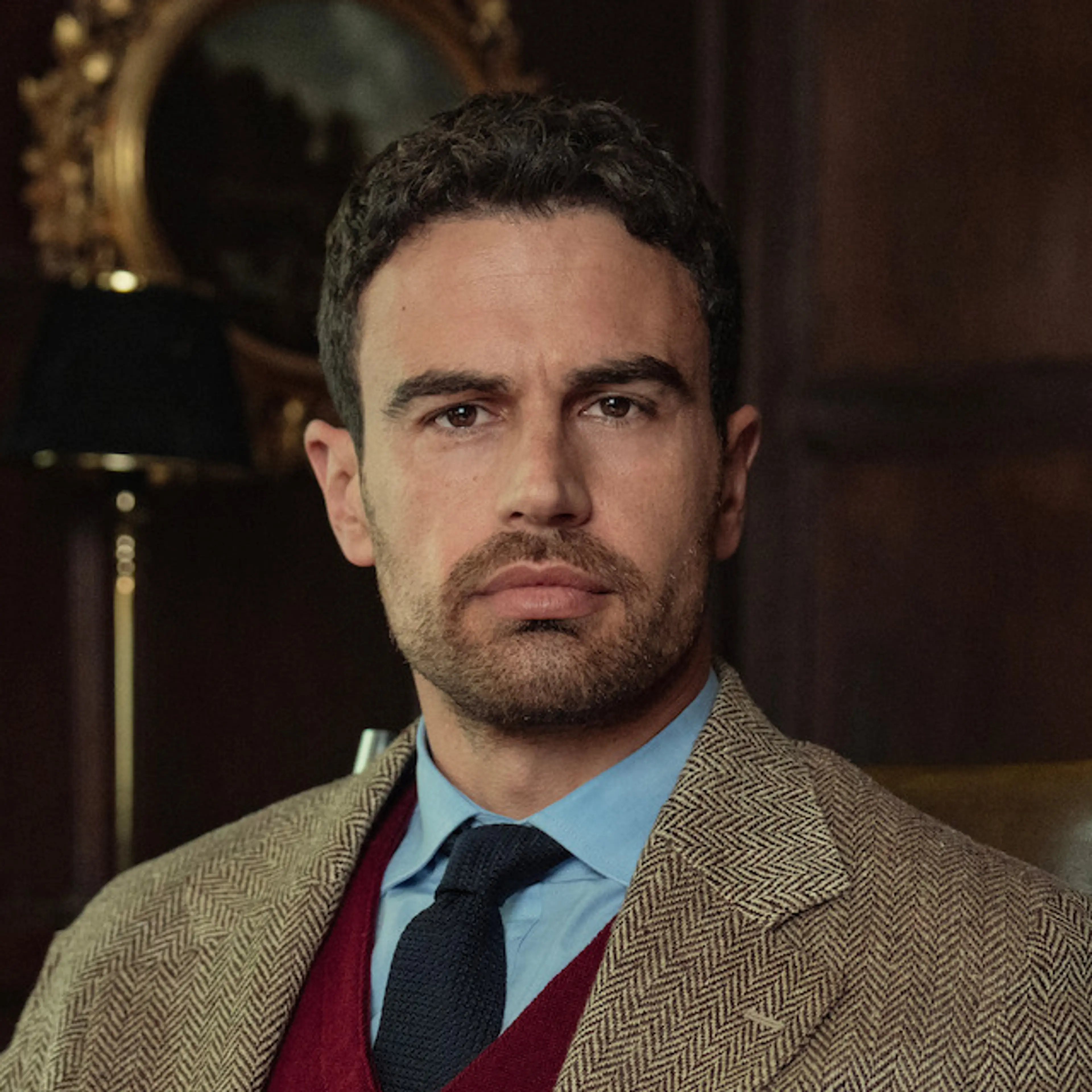 Close-up of Theo James as Eddie Horniman in a brown suit.