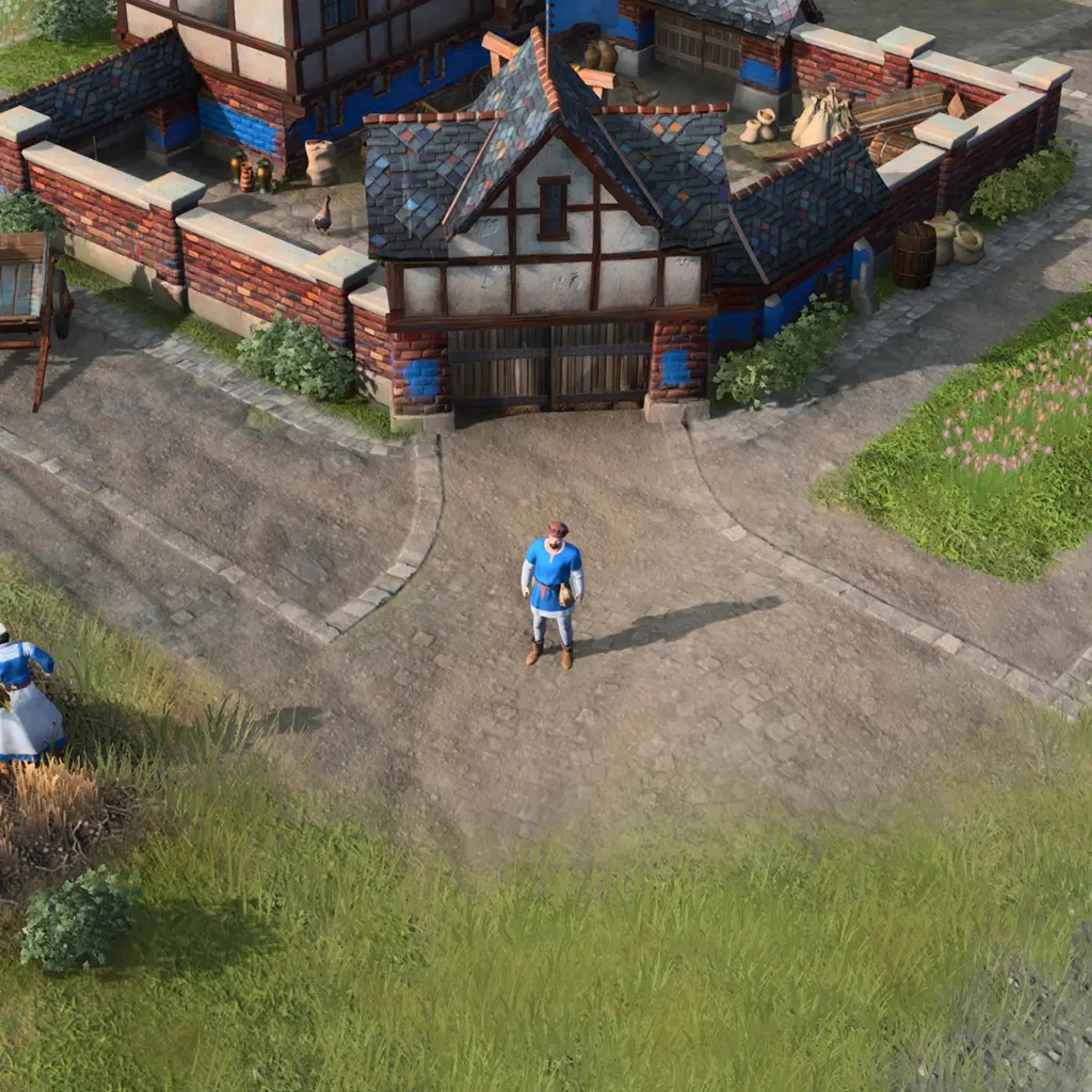 An English villager stands below the buildings. Workers are small at normal zoom: select one and confirm “Villager” in the unit panel before giving a building or gathering order.