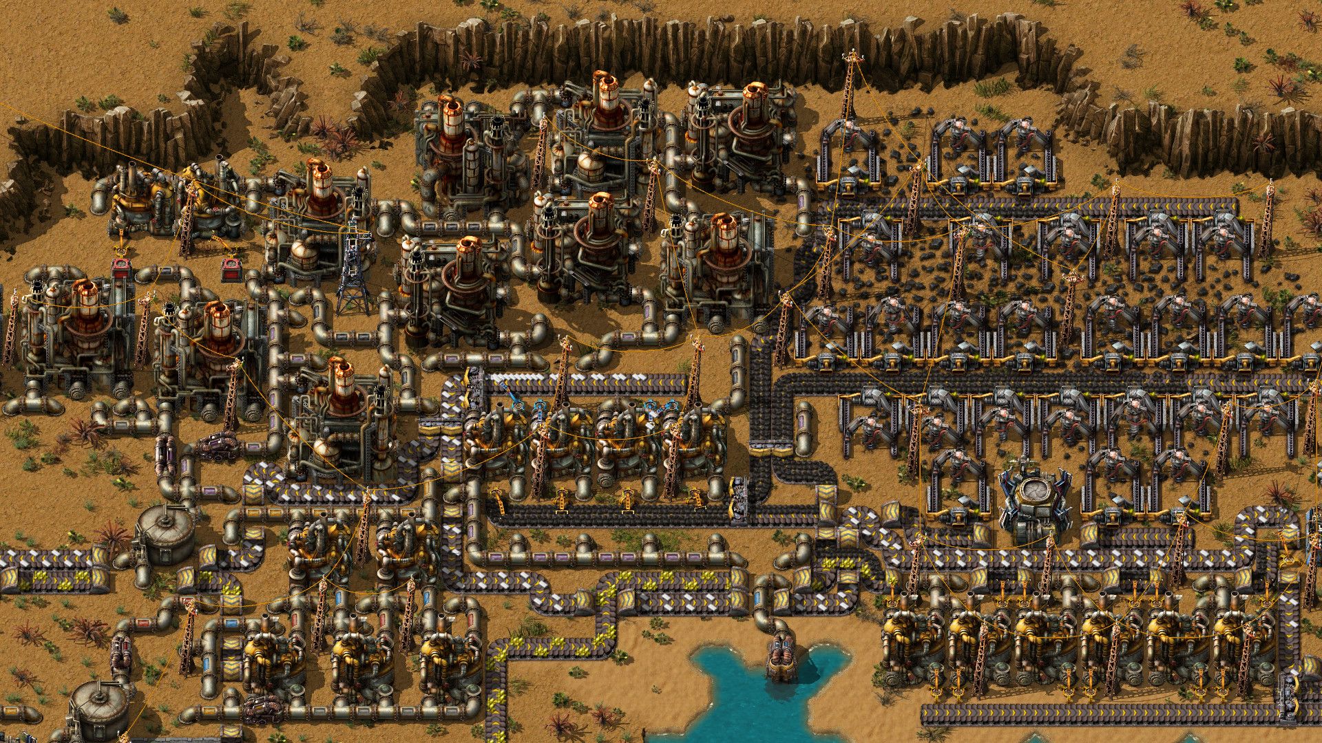 A larger factory shows many connected production structures across the ground.