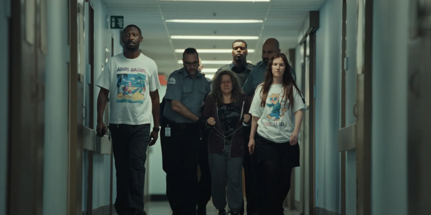 The Empathie ensemble walks through a hospital corridor with security staff.