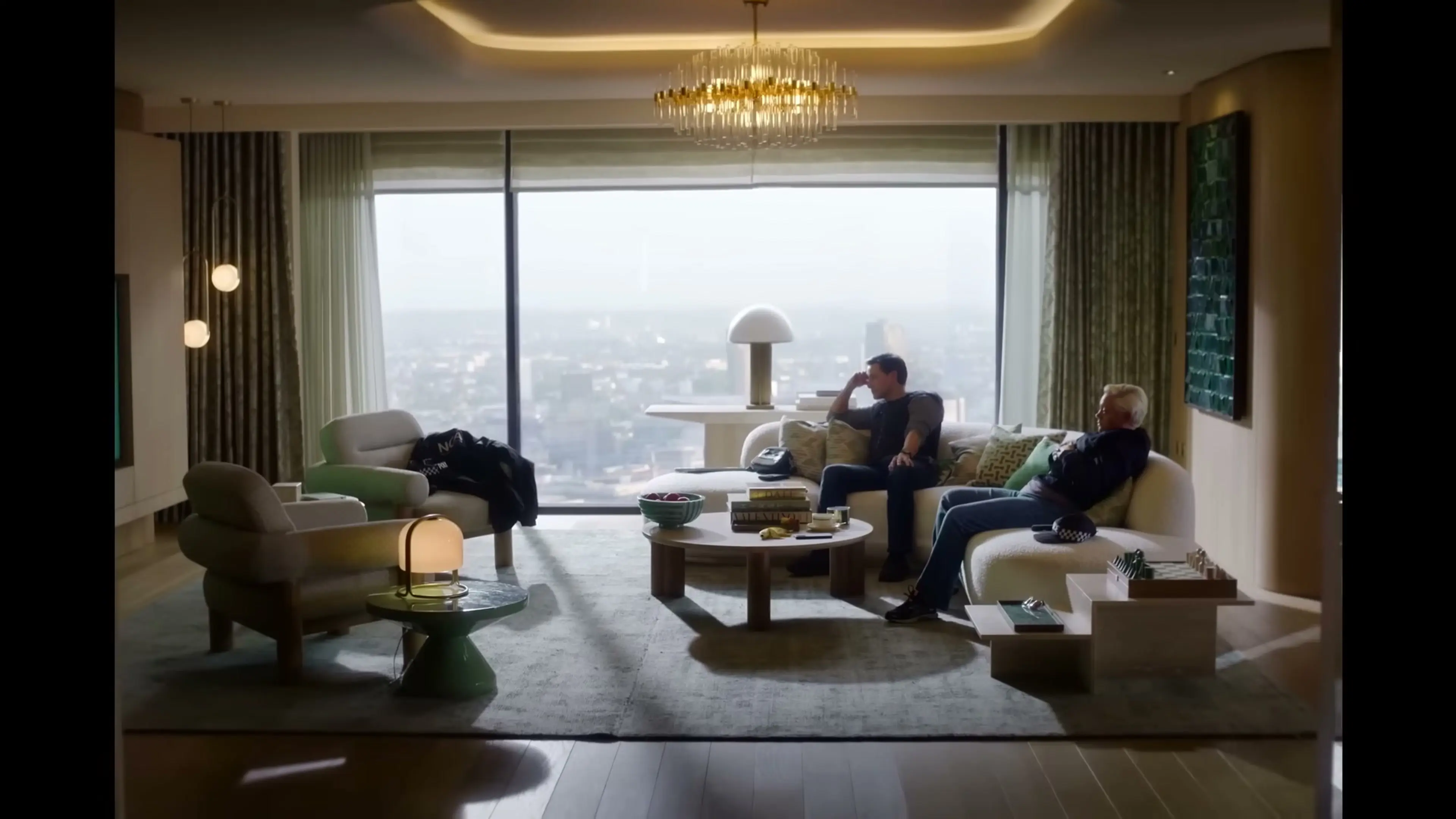 Two men sit inside a high-rise apartment during The Runner.
