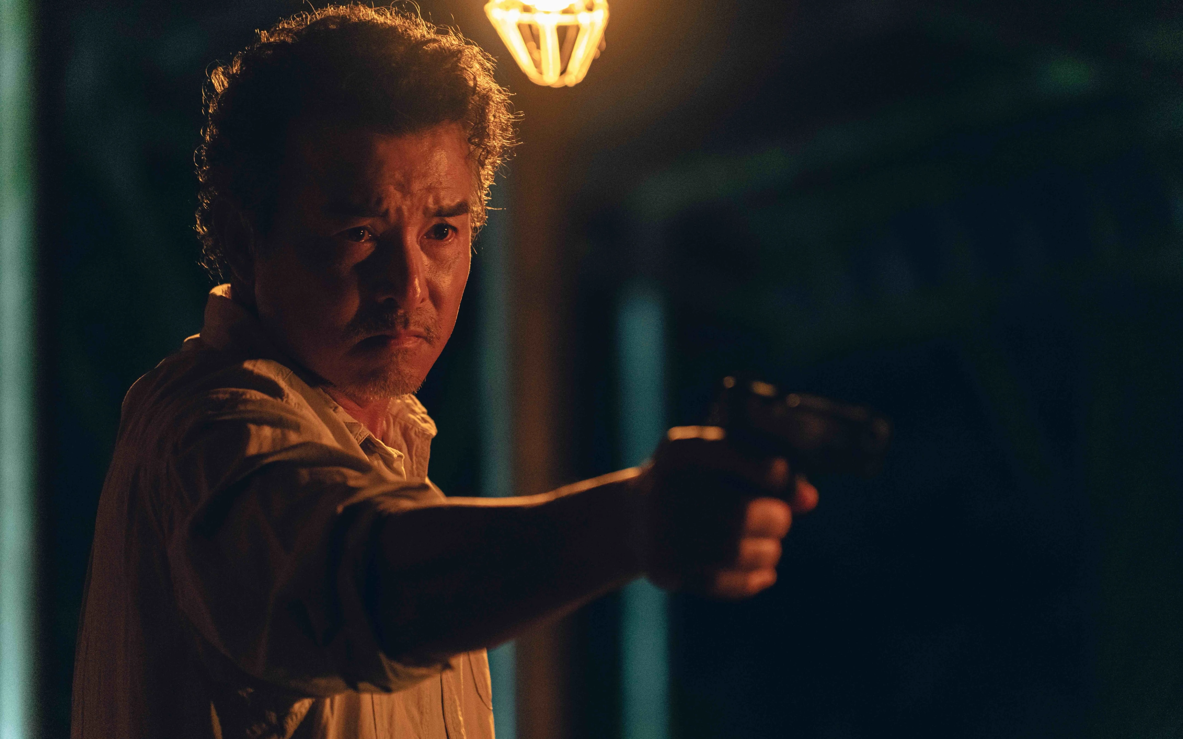 Christopher Lee as Felix Chiang points a gun in official The Fixers artwork.