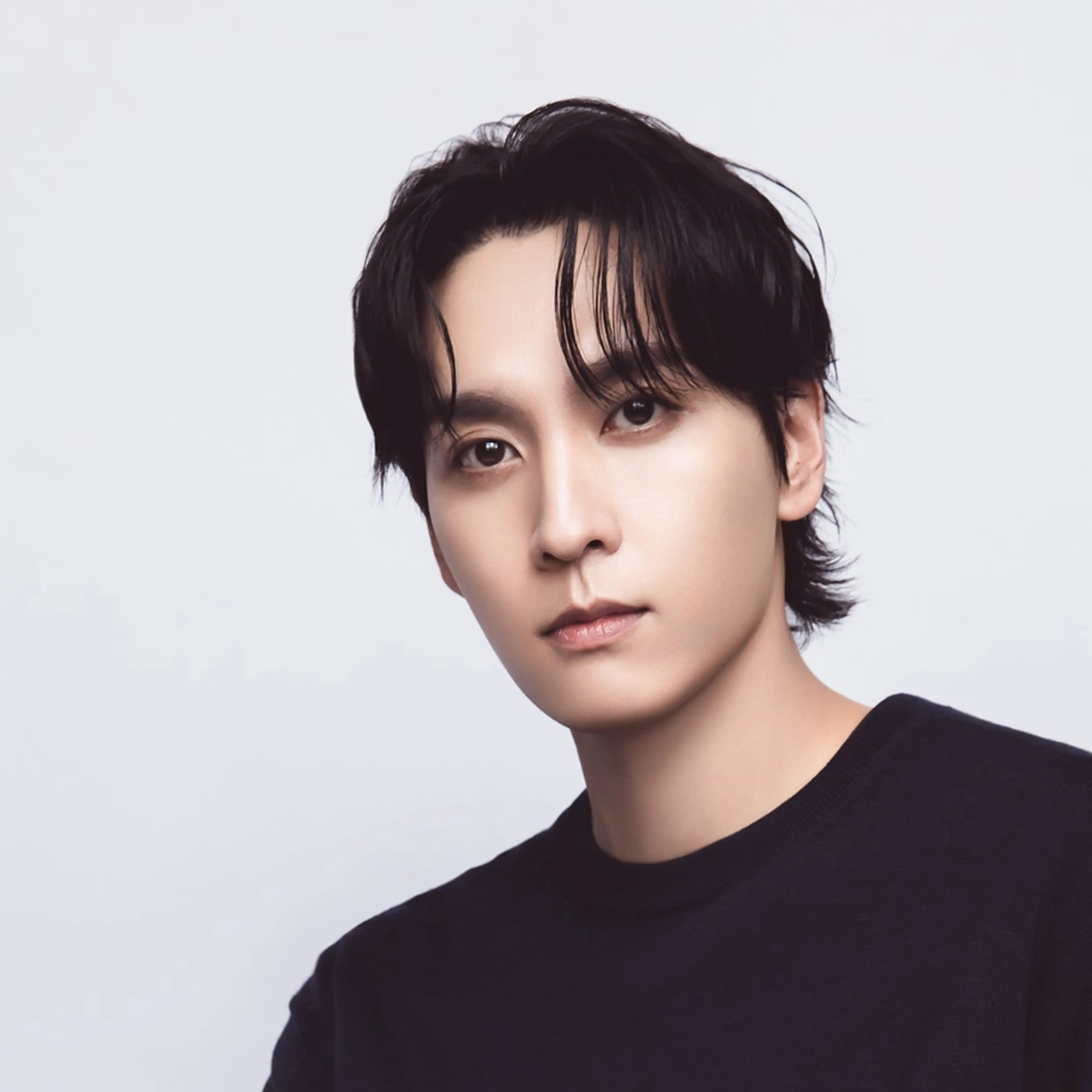 Choi Tae-joon in a black shirt against a pale backdrop.