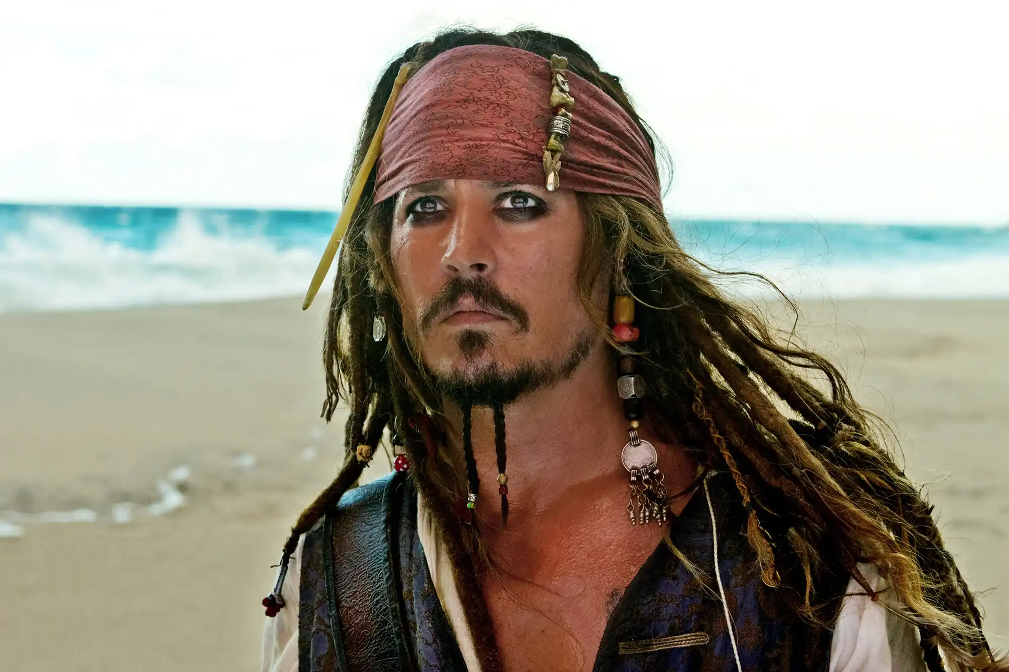 Jack Sparrow stands on a beach in Pirates of the Caribbean: On Stranger Tides.