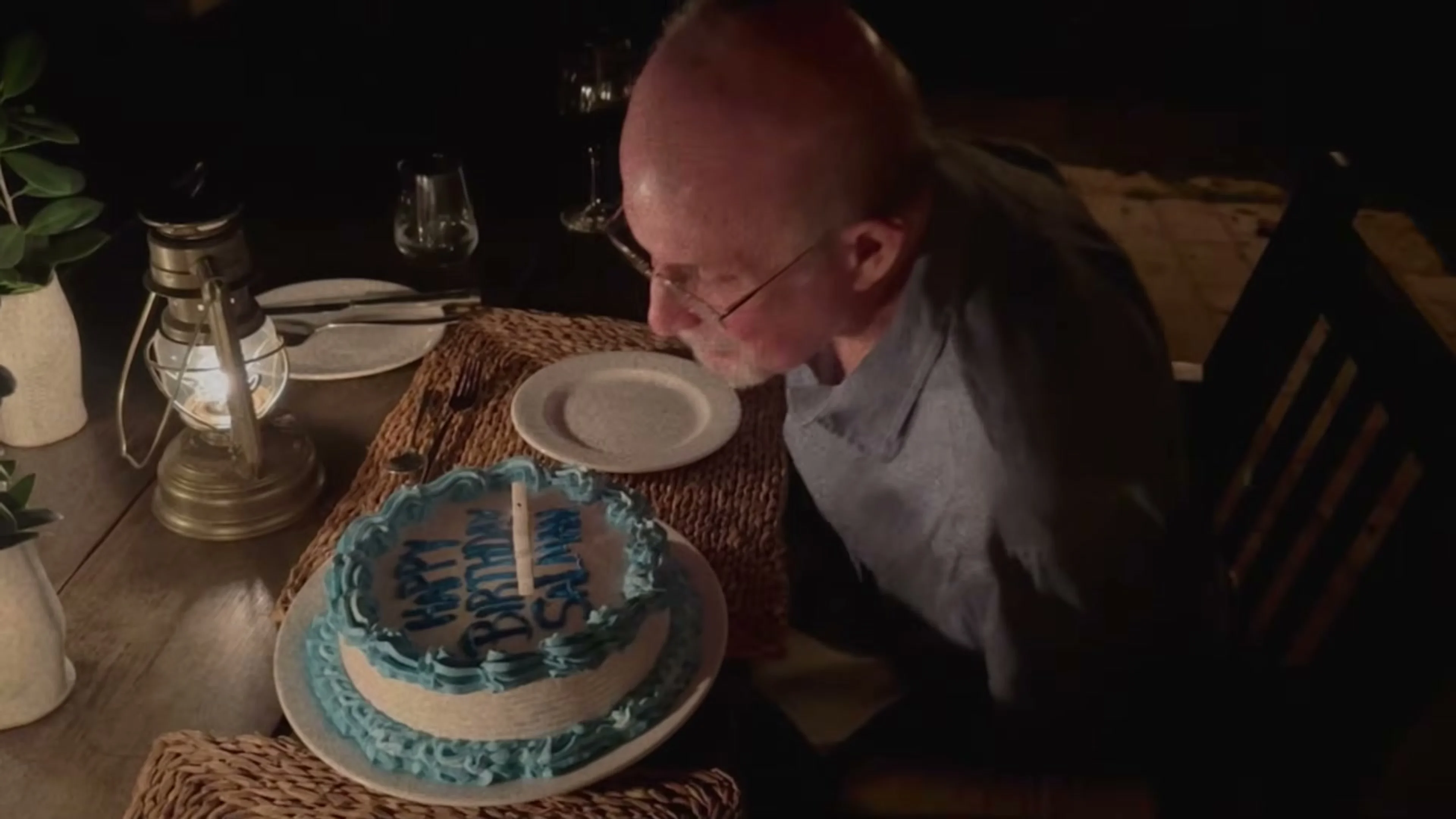 Salman Rushdie leans toward a birthday cake during his recovery.