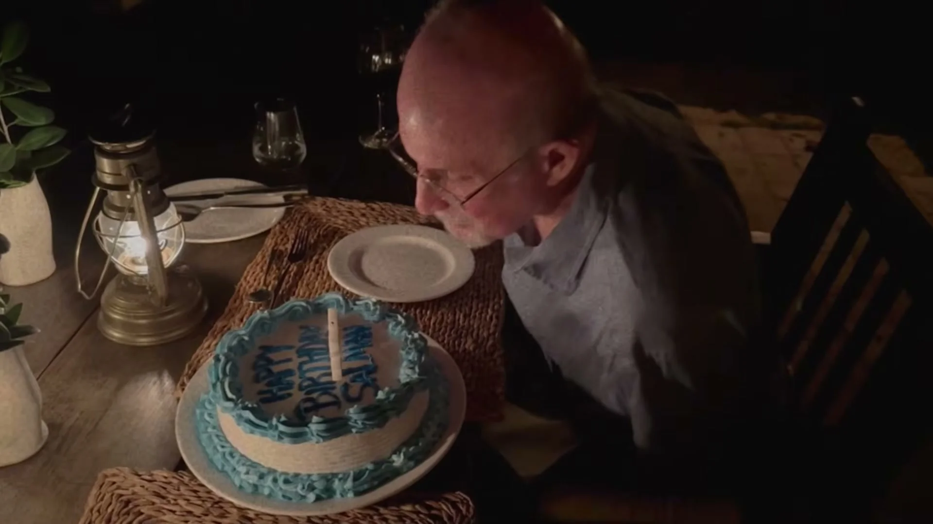 Salman Rushdie leans toward a birthday cake during his recovery.