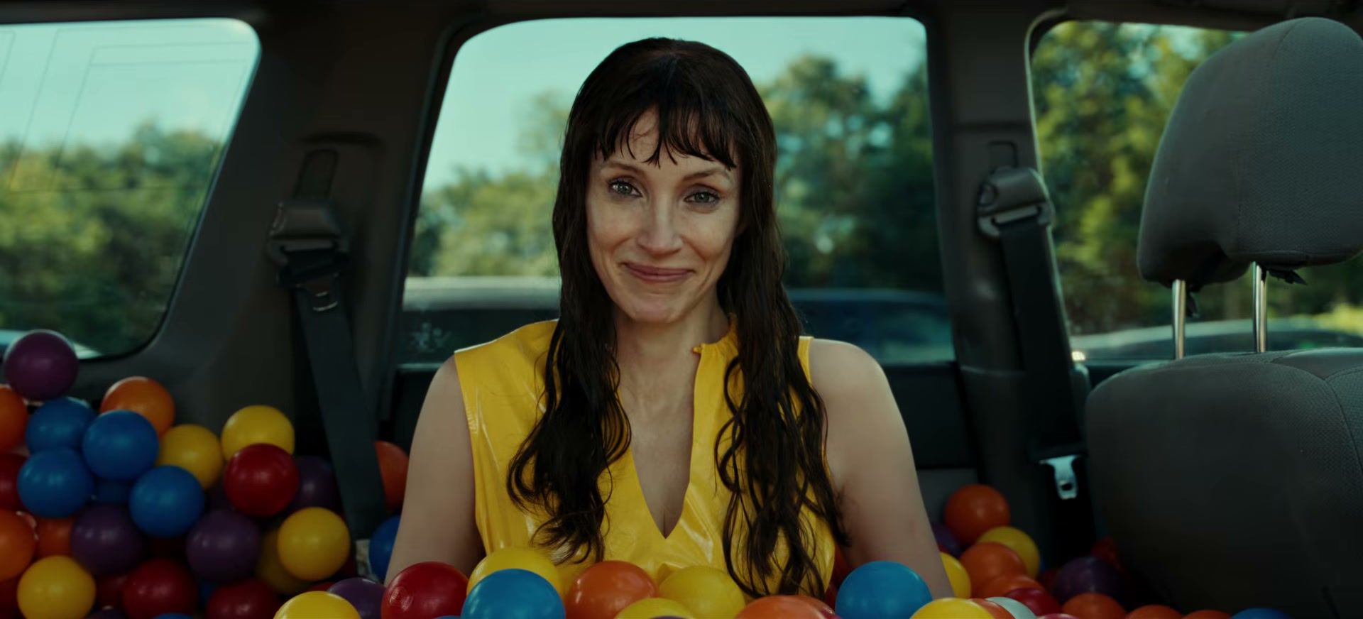 Jessica Chastain as Other Mommy sits inside a car filled with colorful plastic balls.