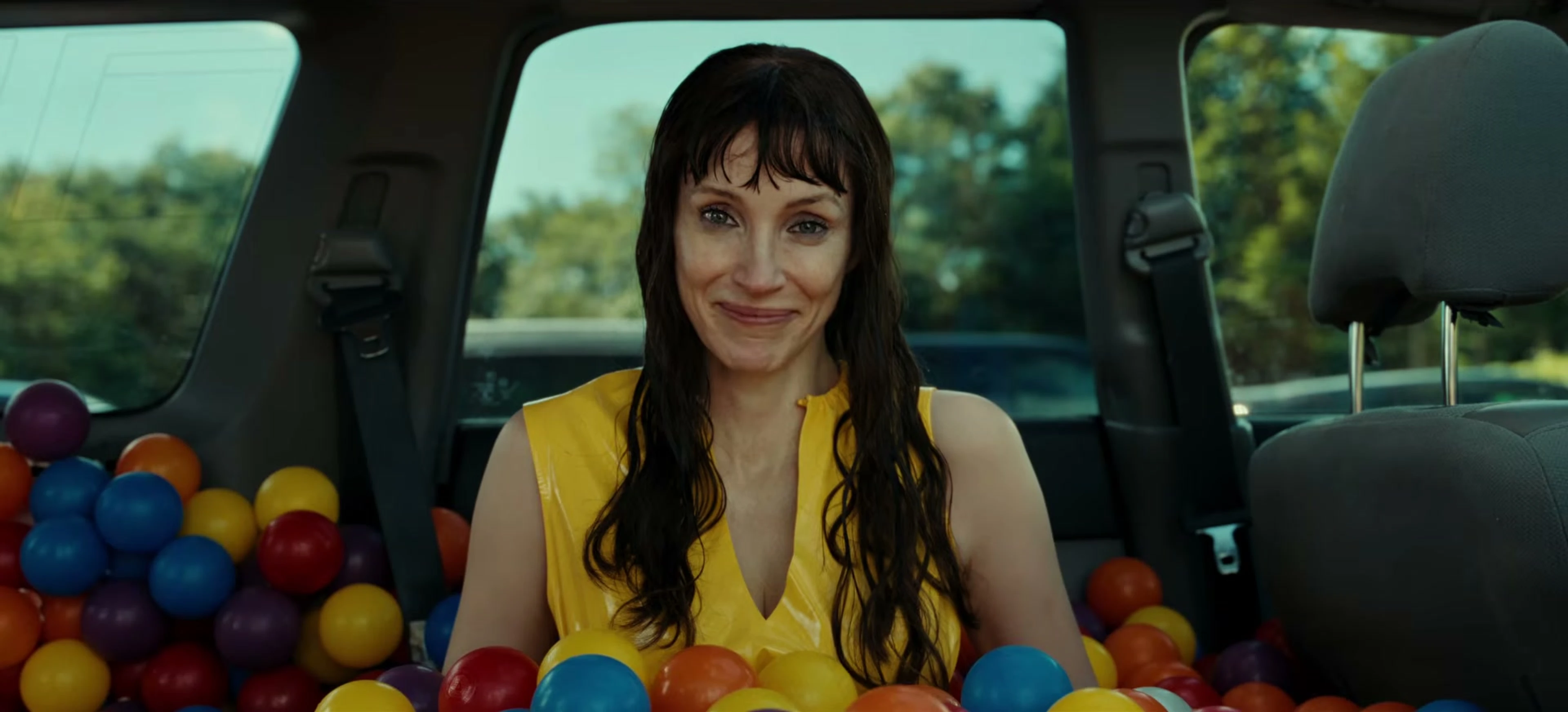 Jessica Chastain as Other Mommy sits inside a car filled with colorful plastic balls.