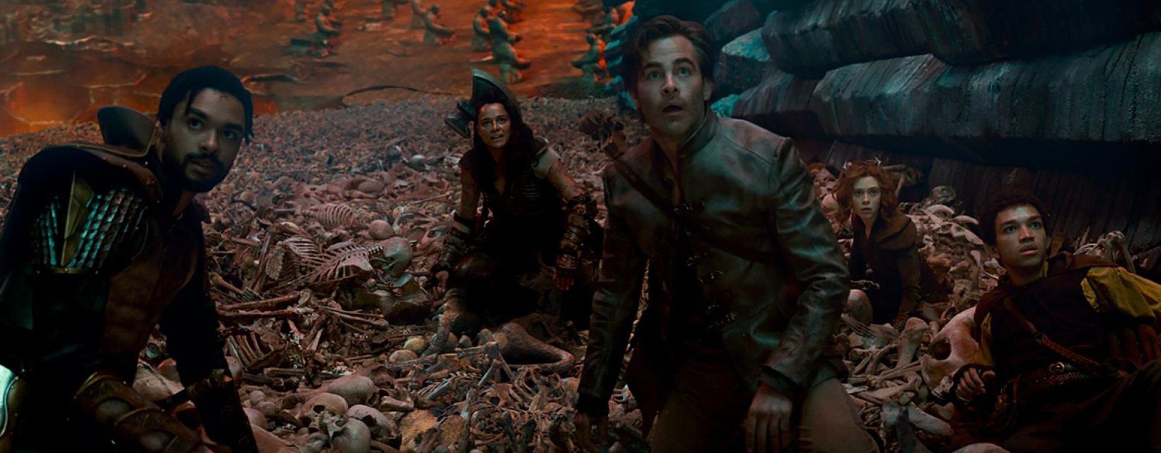 The adventuring party looks up while surrounded by bones in Dungeons & Dragons: Honor Among Thieves.
