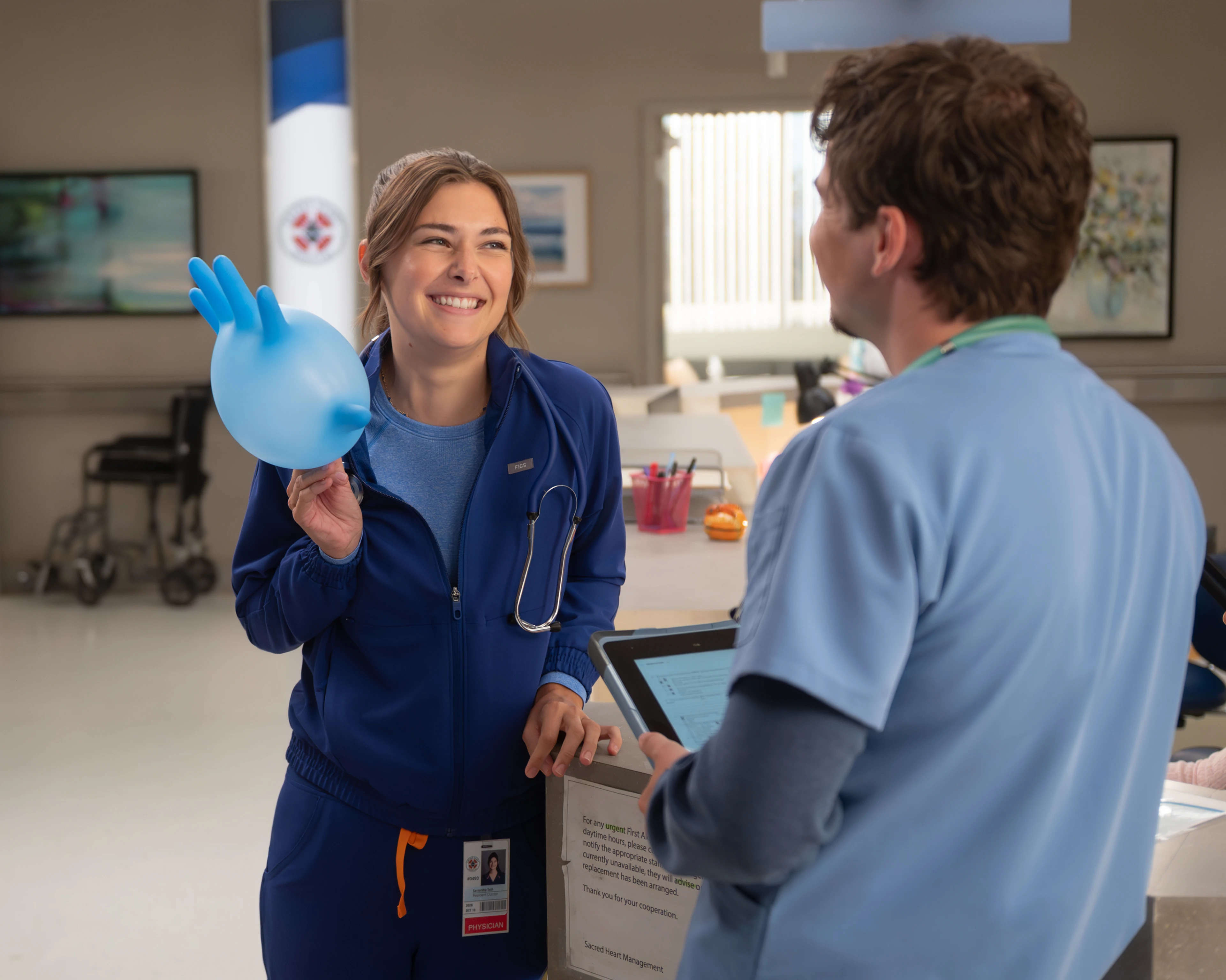 Ava Bunn as Sam Tosh smiles while holding an inflated blue glove at Sacred Heart.