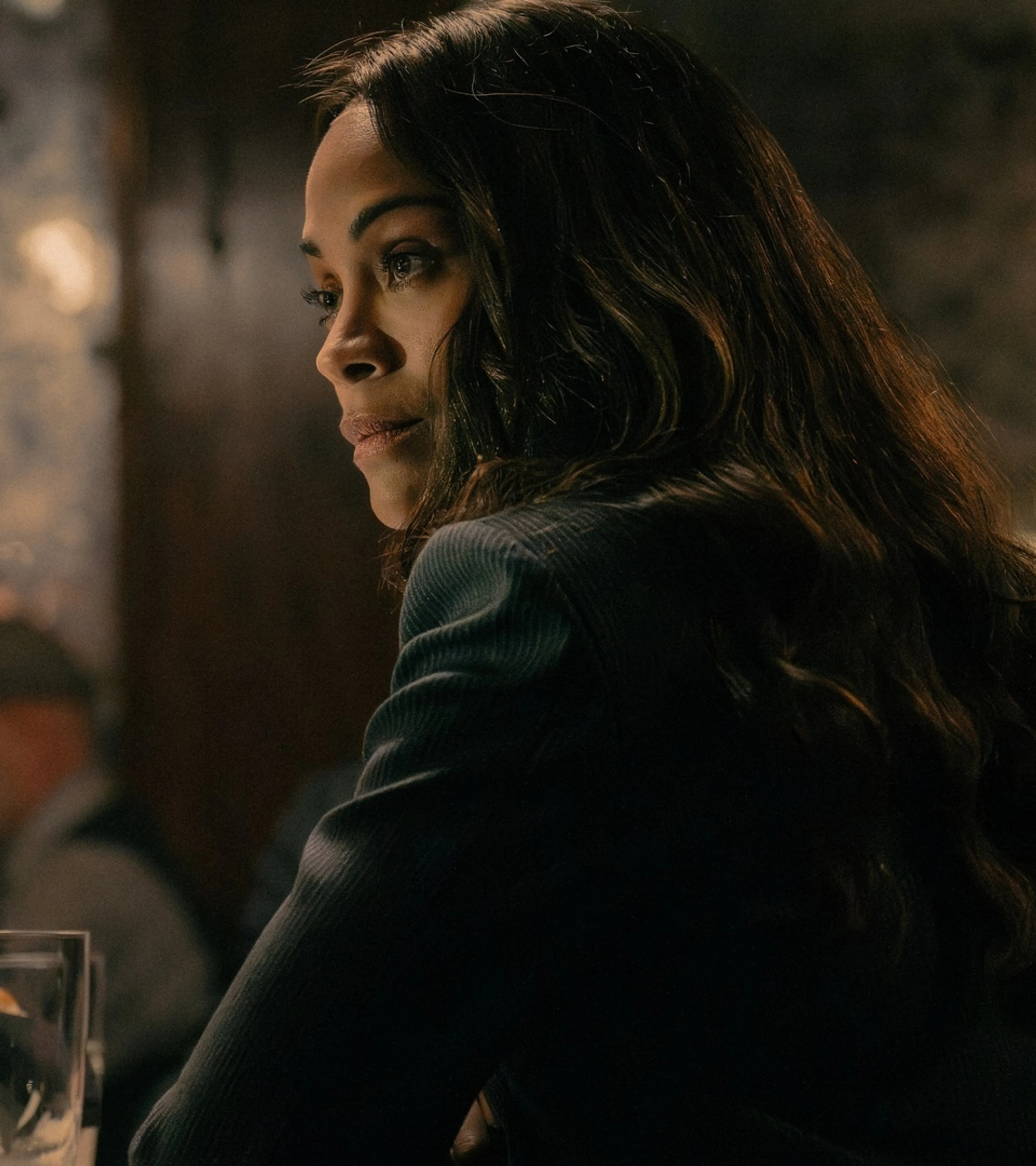 Zoe Saldaña as Joe sits at a table with Morgan Freeman as Edwin Mullins in Lioness Season 3.