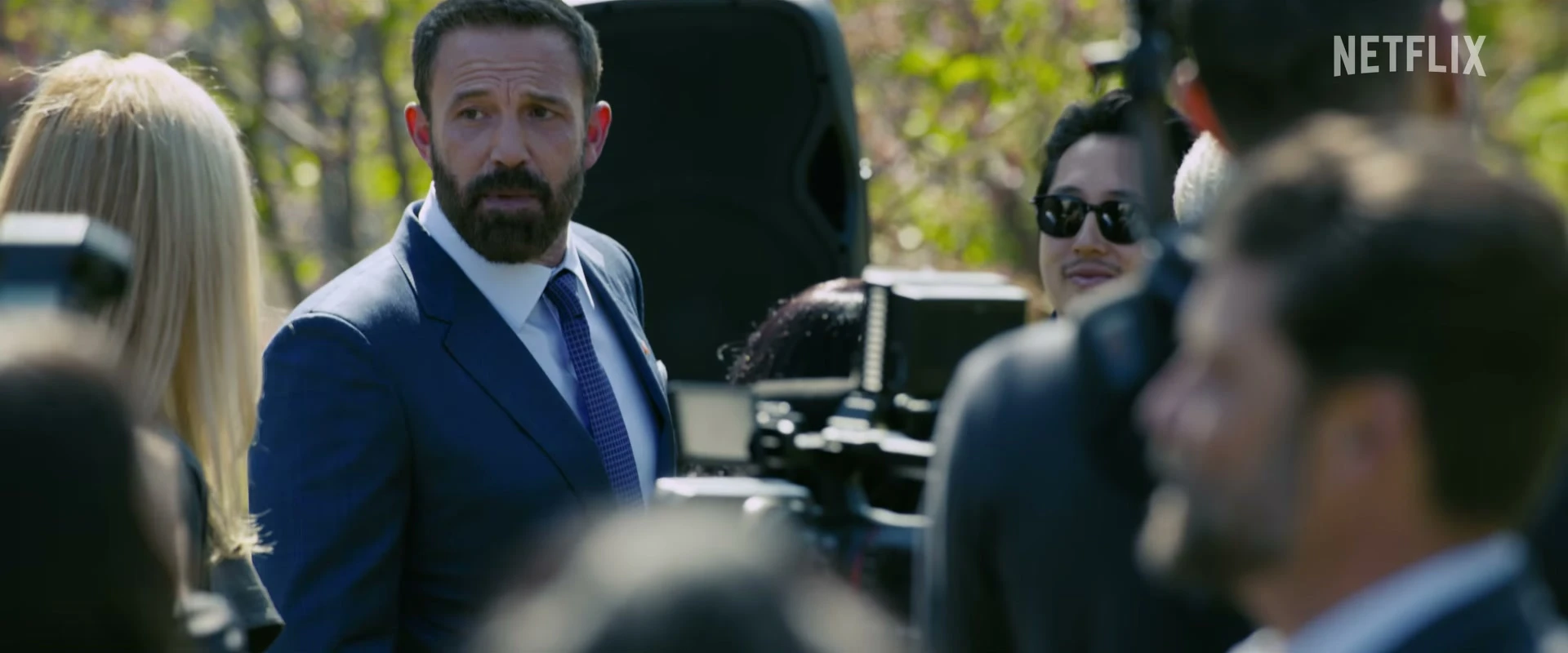 Ben Affleck as Mark Kimball turns toward reporters at an outdoor campaign event in Animals.