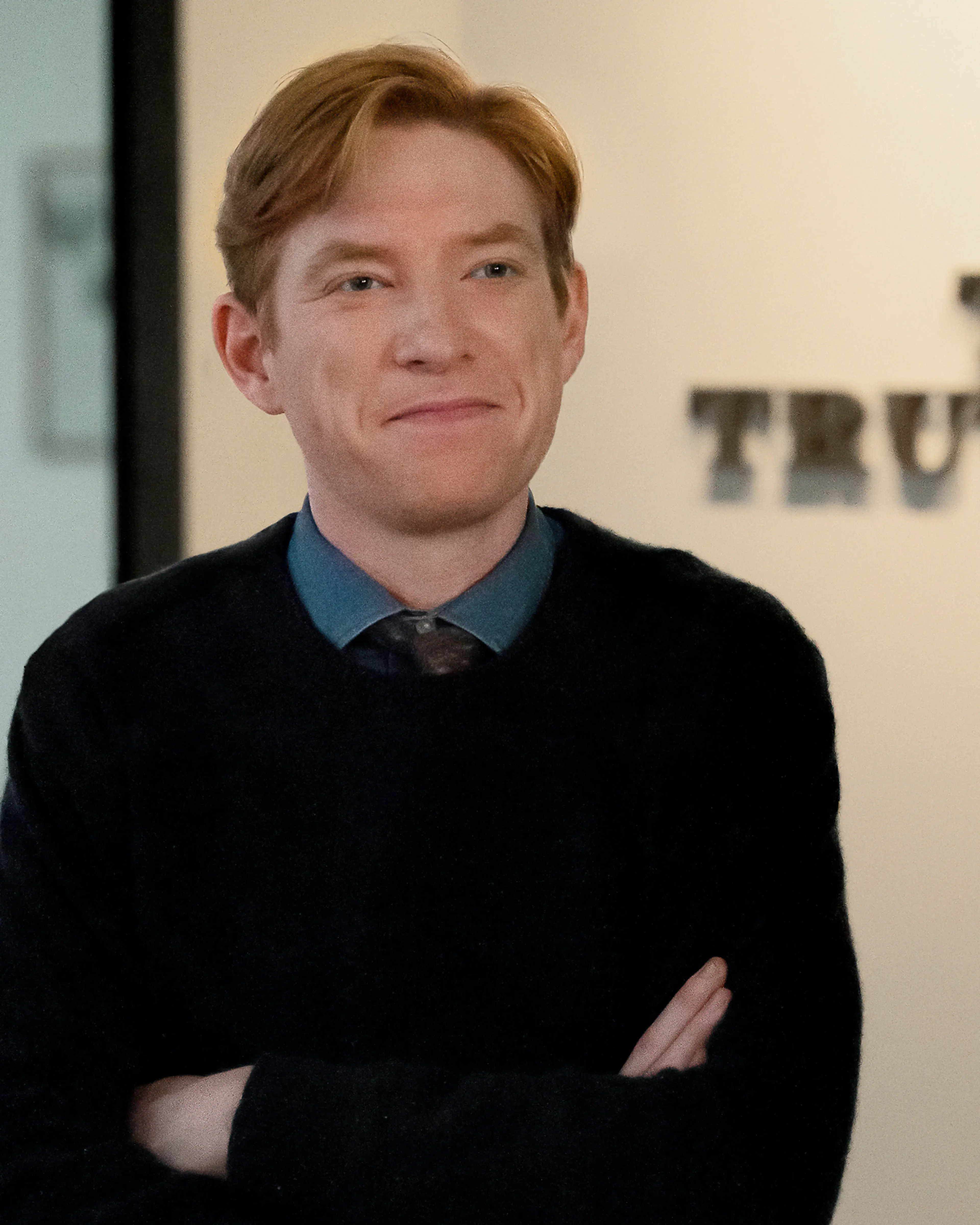 Ned Sampson stands with his arms folded beside the Toledo Truth Teller sign.