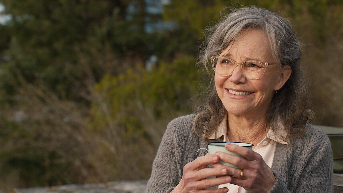 Sally Field as Tova smiles while holding a cup in official Remarkably Bright Creatures artwork.