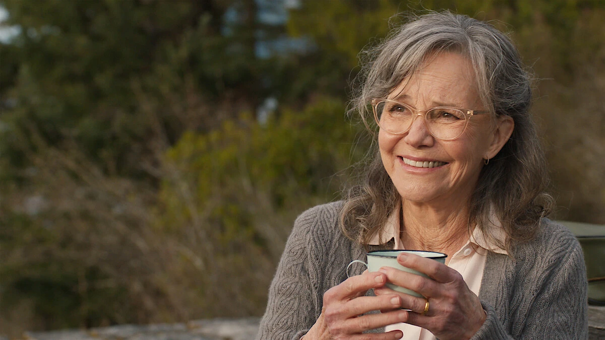 Sally Field as Tova smiles while holding a cup in official Remarkably Bright Creatures artwork.