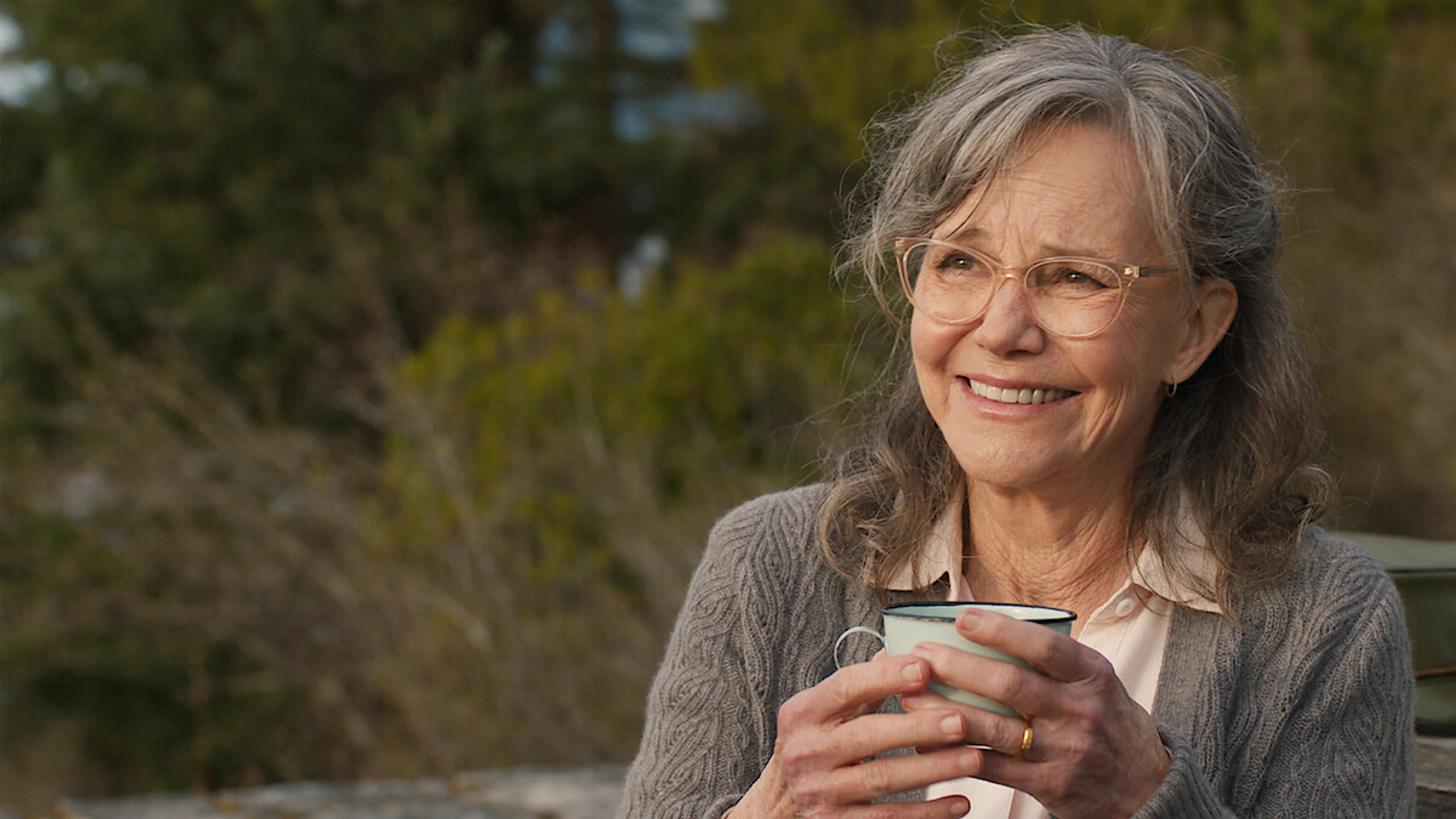 Sally Field as Tova smiles while holding a cup in official Remarkably Bright Creatures artwork.